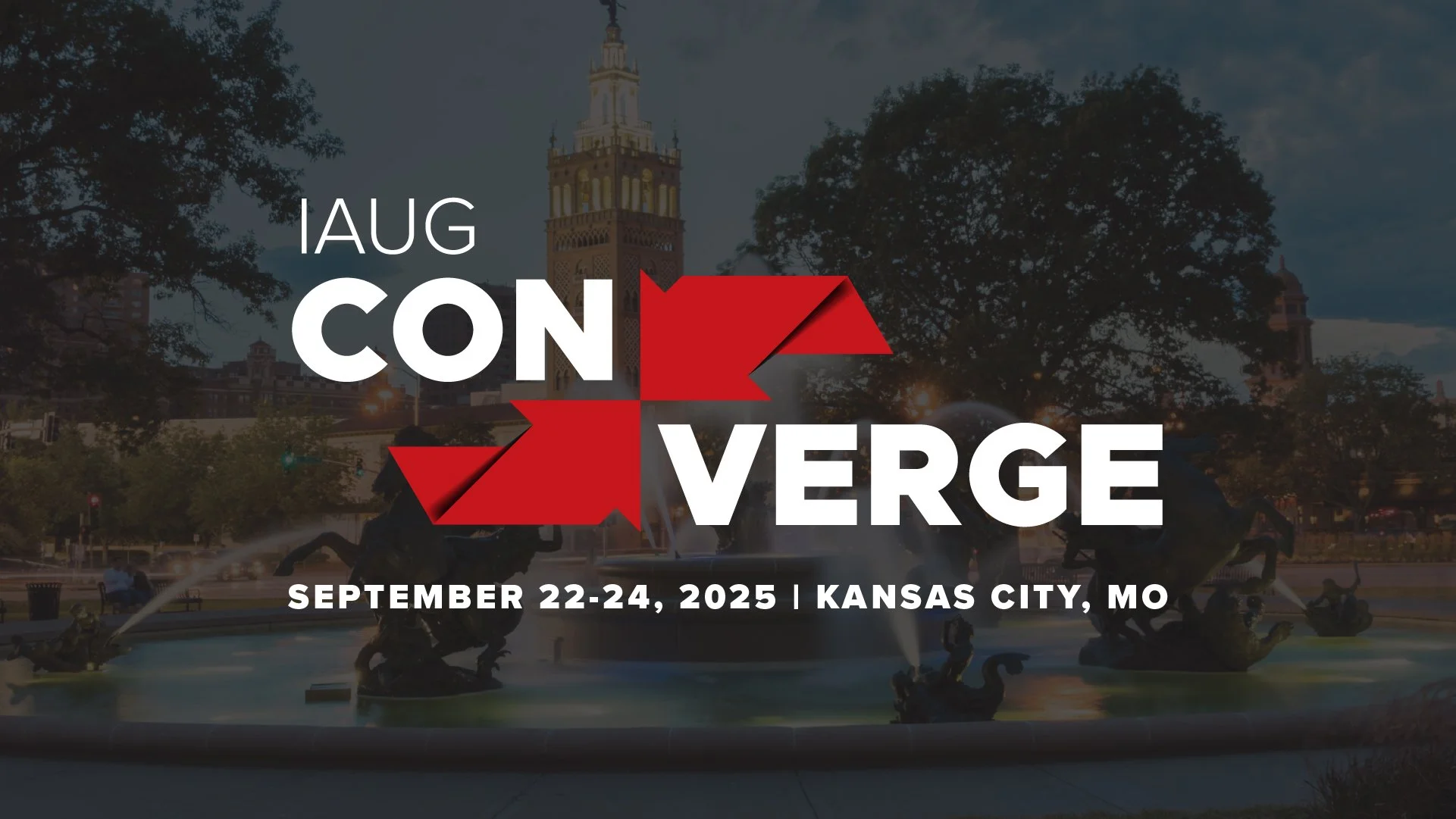 A promotional graphic for the IAUG Conference in Kansas City, MO, scheduled for September 22 to 24, 2025. The background shows a nighttime cityscape with a fountain and a historic tower illuminated with lights.