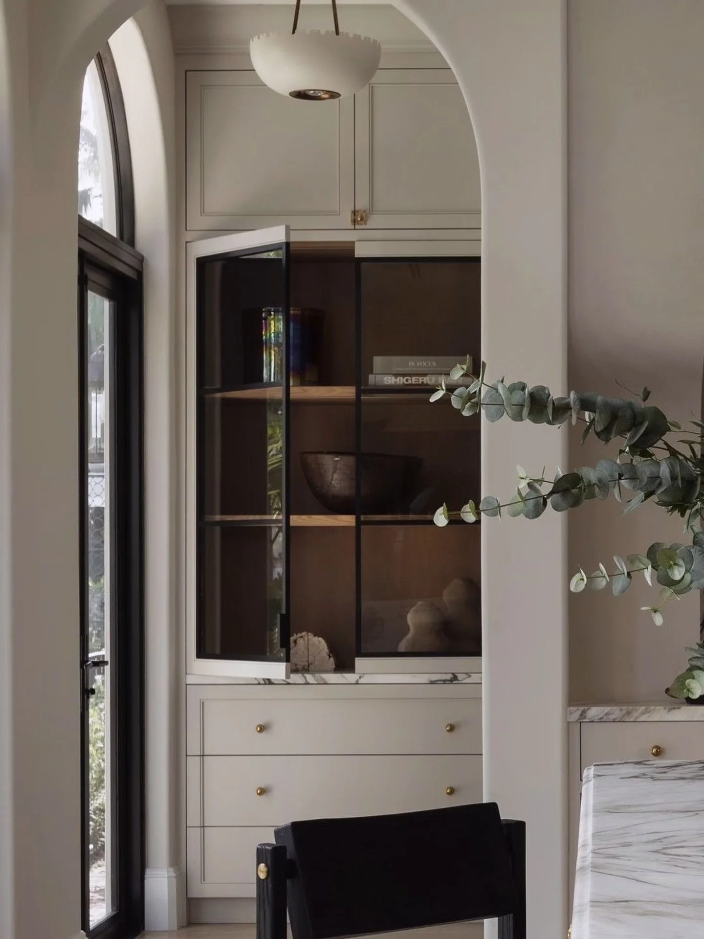 ✨ Quiet luxury lives in the details.
This built-in moment blends soft arches, natural light, and clean lines&mdash;anchored by a custom cabinet that feels both timeless and tailored. Brass hardware, matte textures, and organic tones come together to 