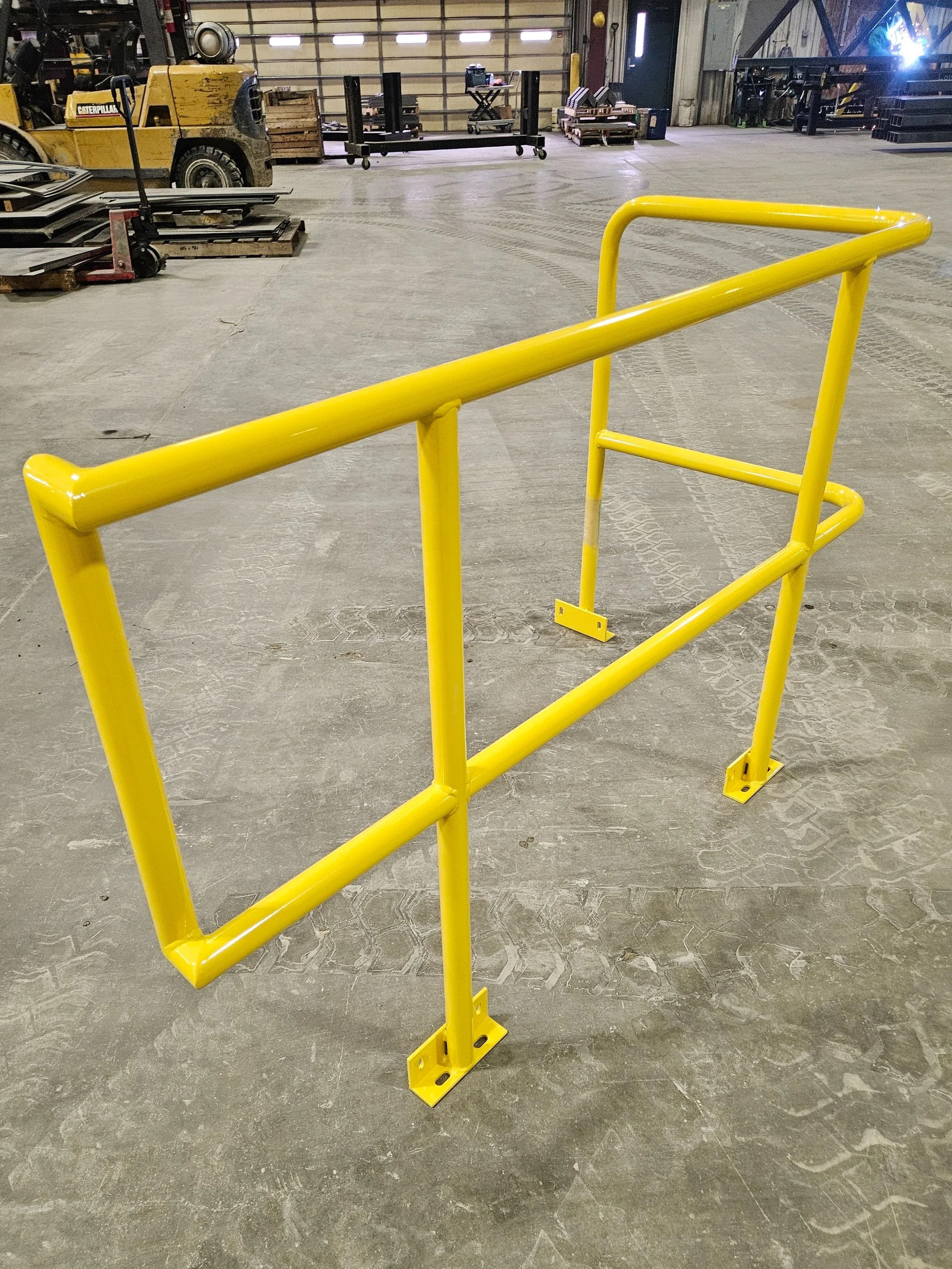 Yellow metal safety barricade with supportive horizontal bars in an industrial warehouse