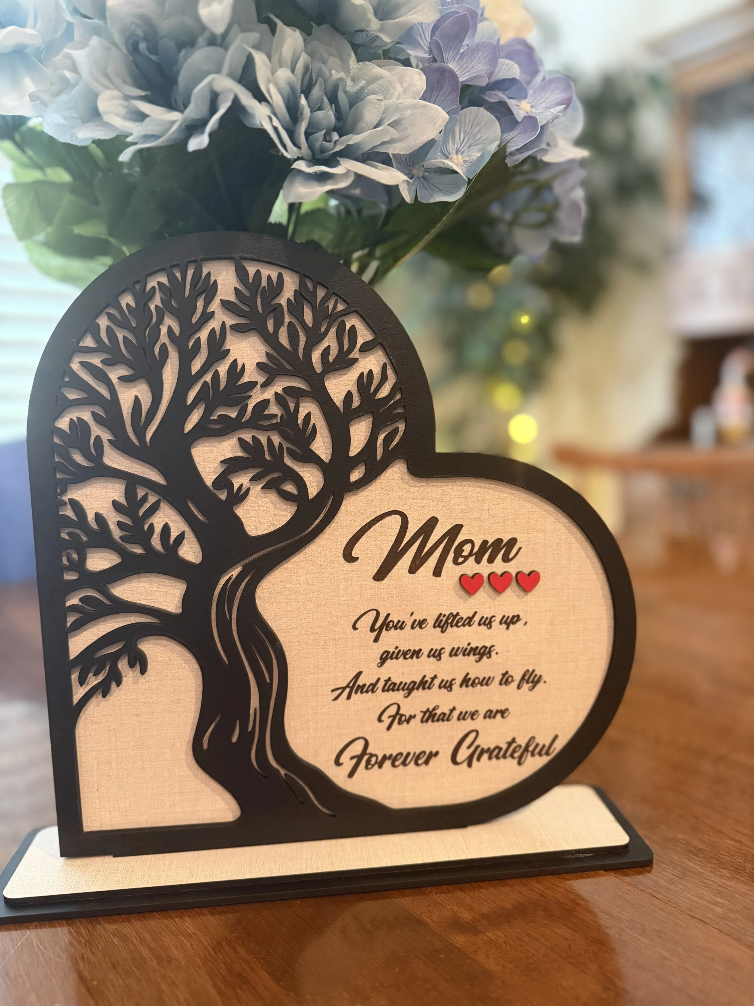 A beauyiful tribute to mom features black, linen and red finished wood and engraved message.