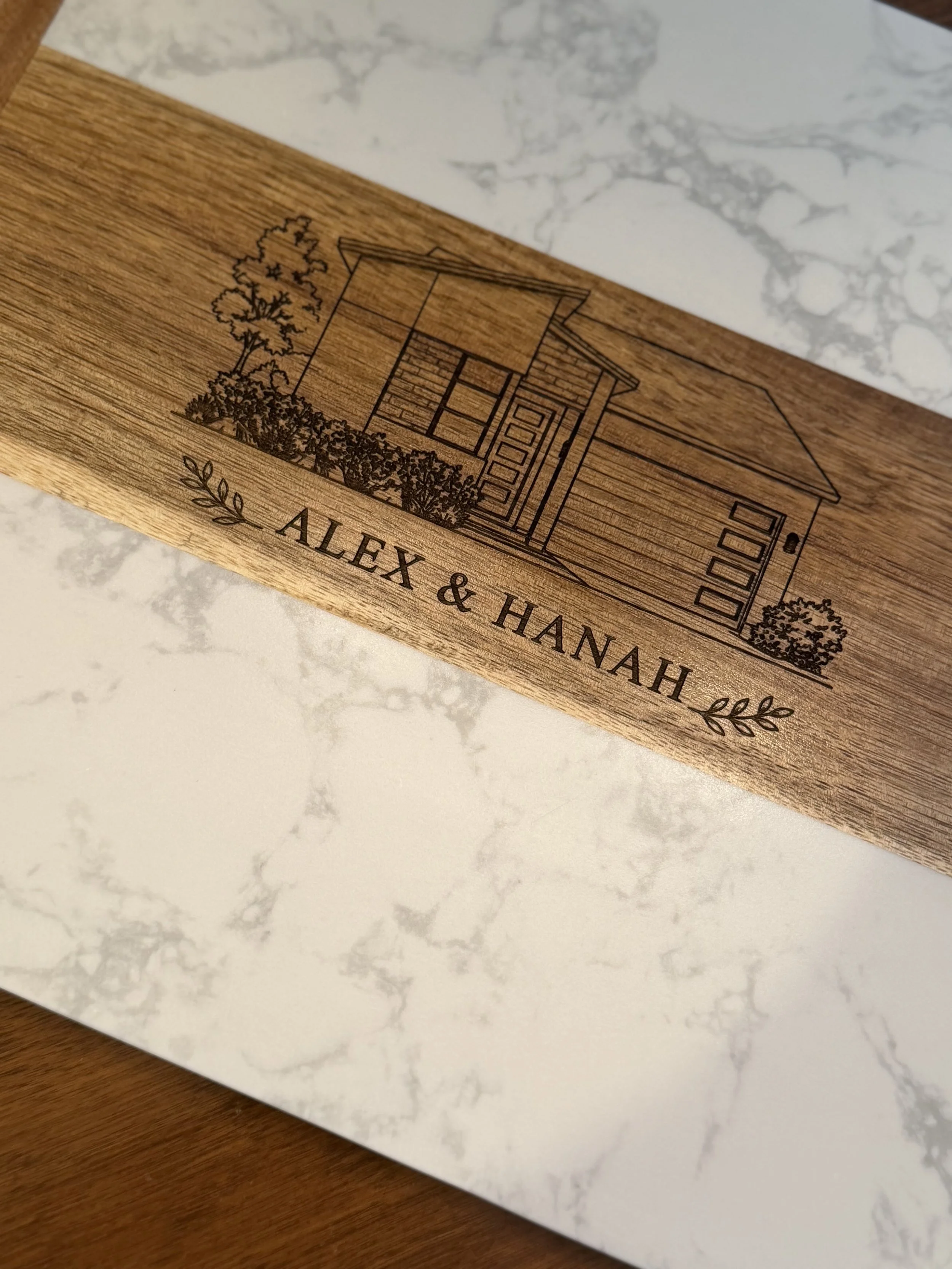 A personalized acacia and marble cutting board for a real estate client's closing gift.