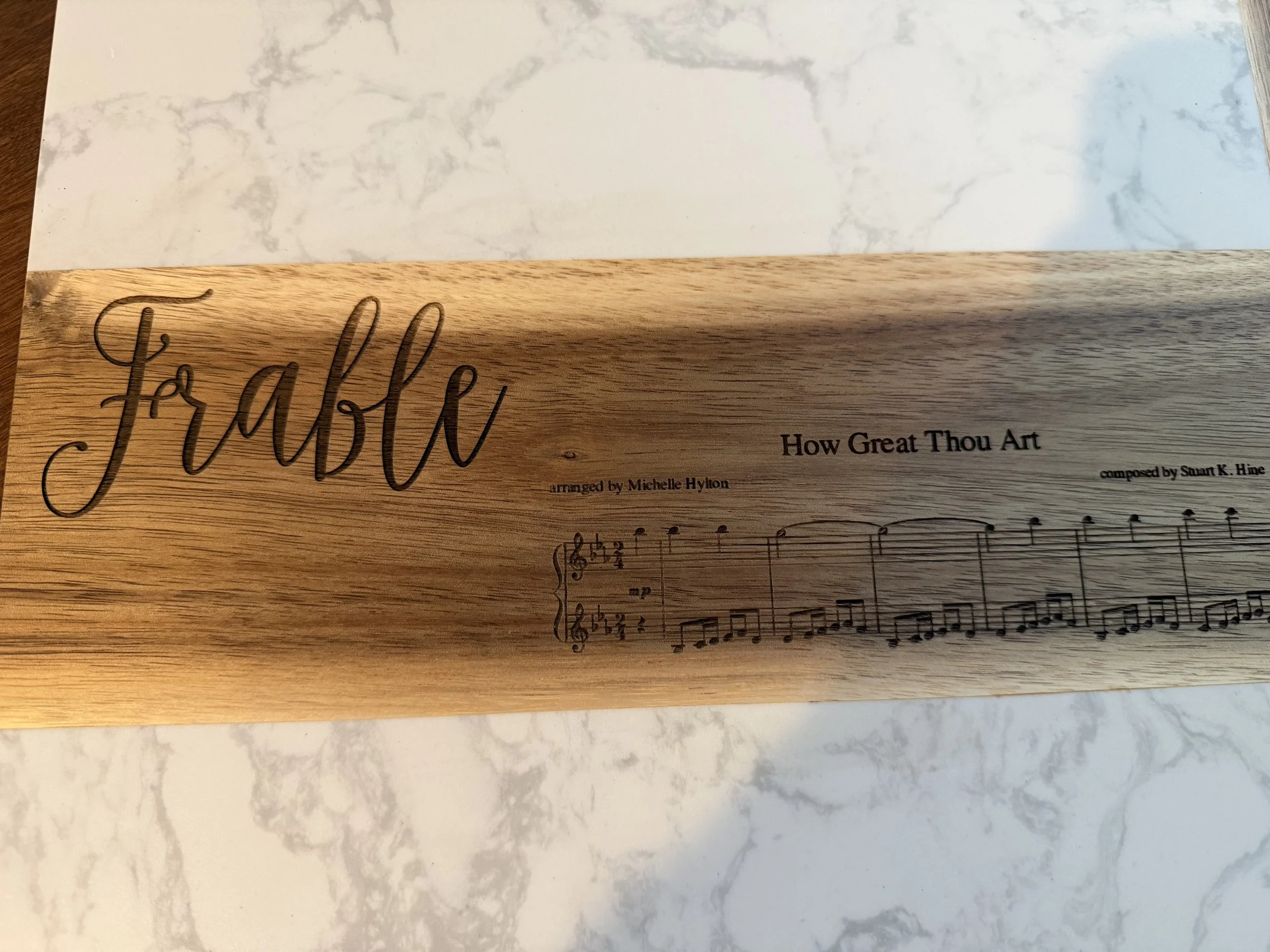 Personalized charcuterie board in marble and acacia for a music director who loves that bar of How Great Thou Art