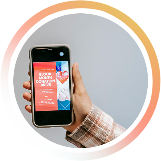 Nahaufnahme einer Person, die ein Smartphone hält, auf dem eine Spendenaktion für den Blutspendetmonat angezeigt wird.