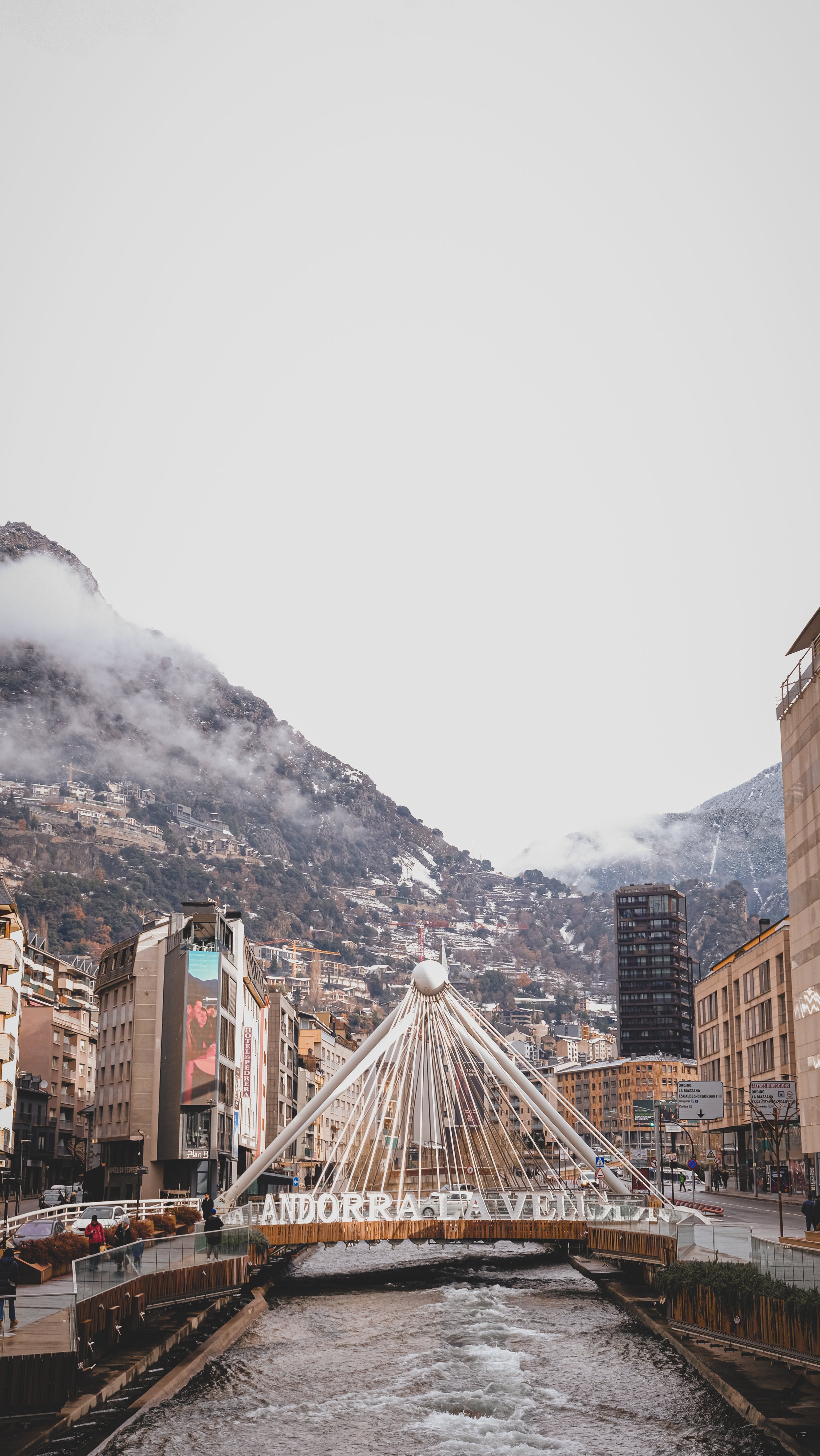 A wooden structure on stilts in a calm lake with a mountain in the background, partially obscured by fog.