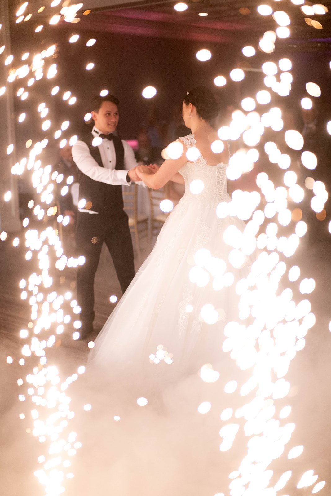Bride and groom dancing surrounded by sparklers at wedding reception