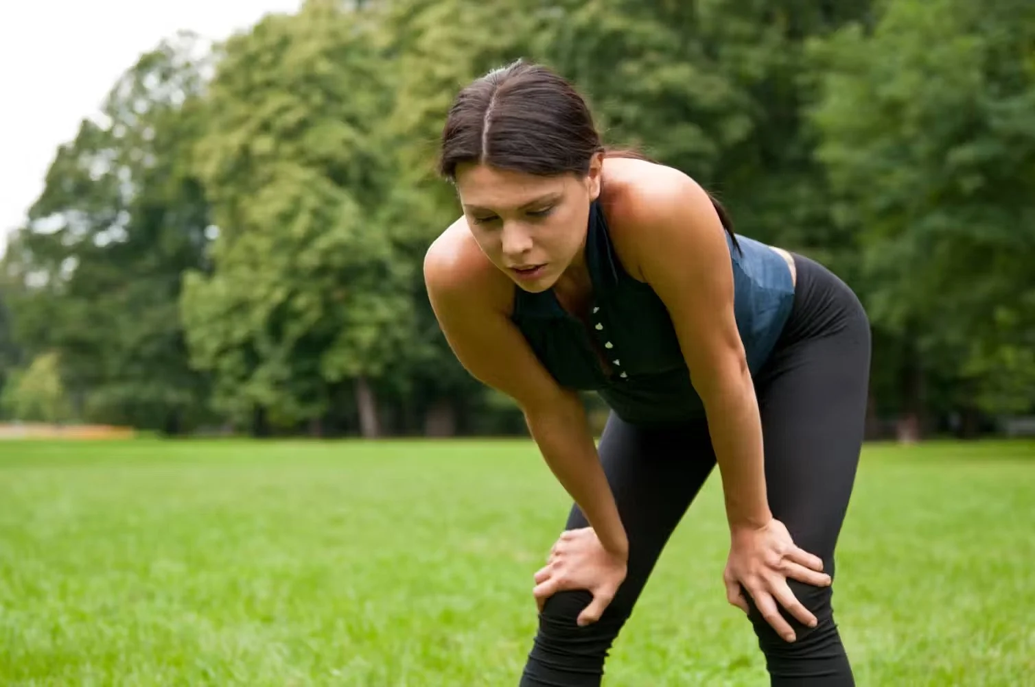 Woman bent over out of breath on a run