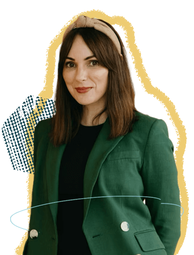 A woman wearing a green blazer and black top, with shoulder-length brown hair, and a beige headband, smiling at the camera.