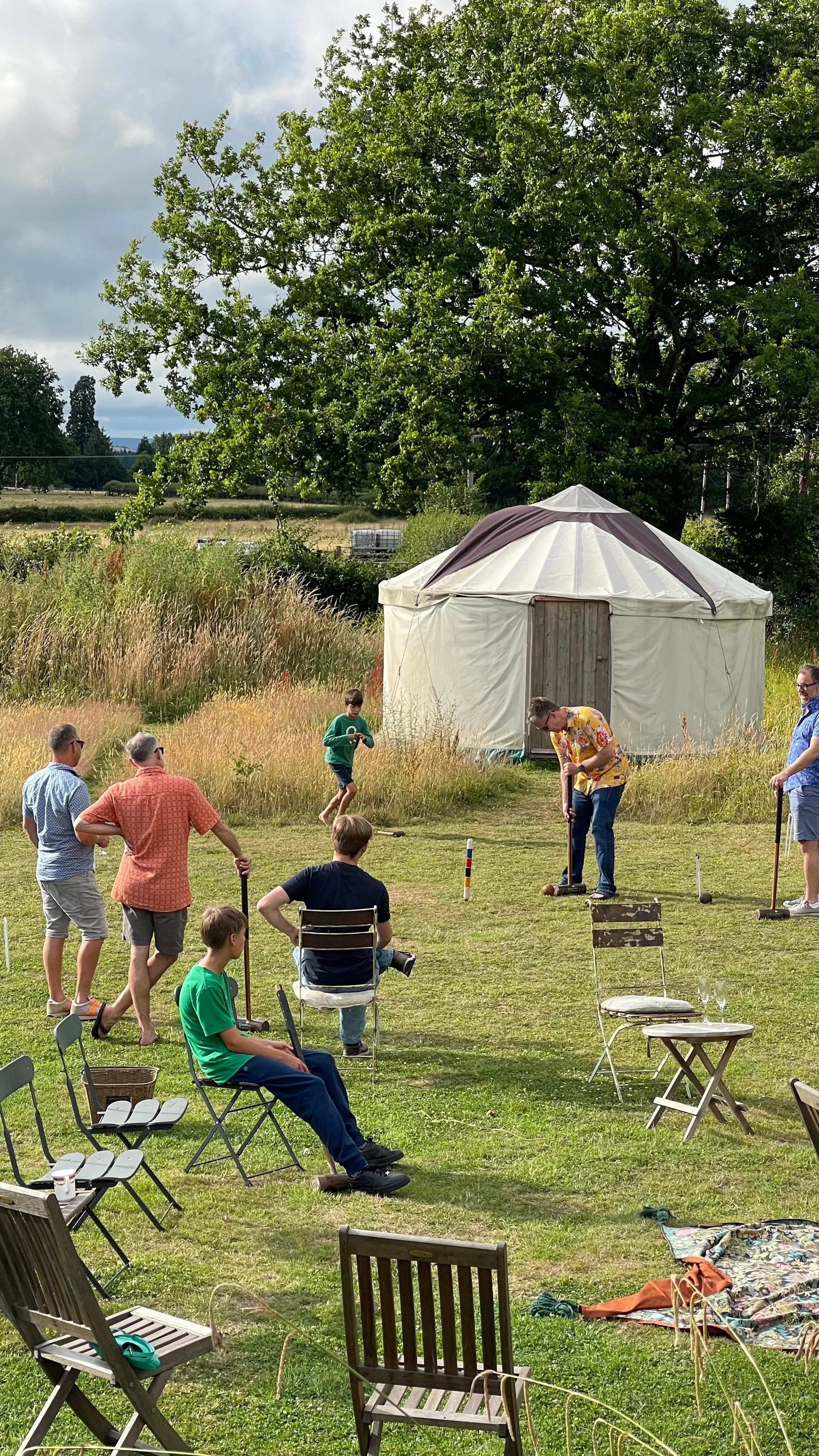 A large family enjoying time together in a field at a group accommodation setting in south wales
