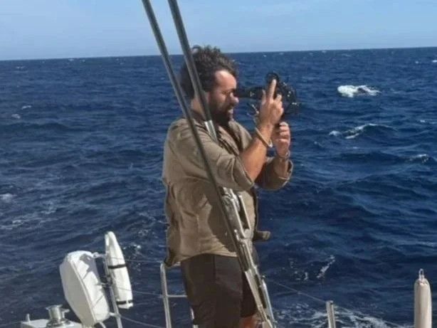 Man using sextant on a boat in the ocean