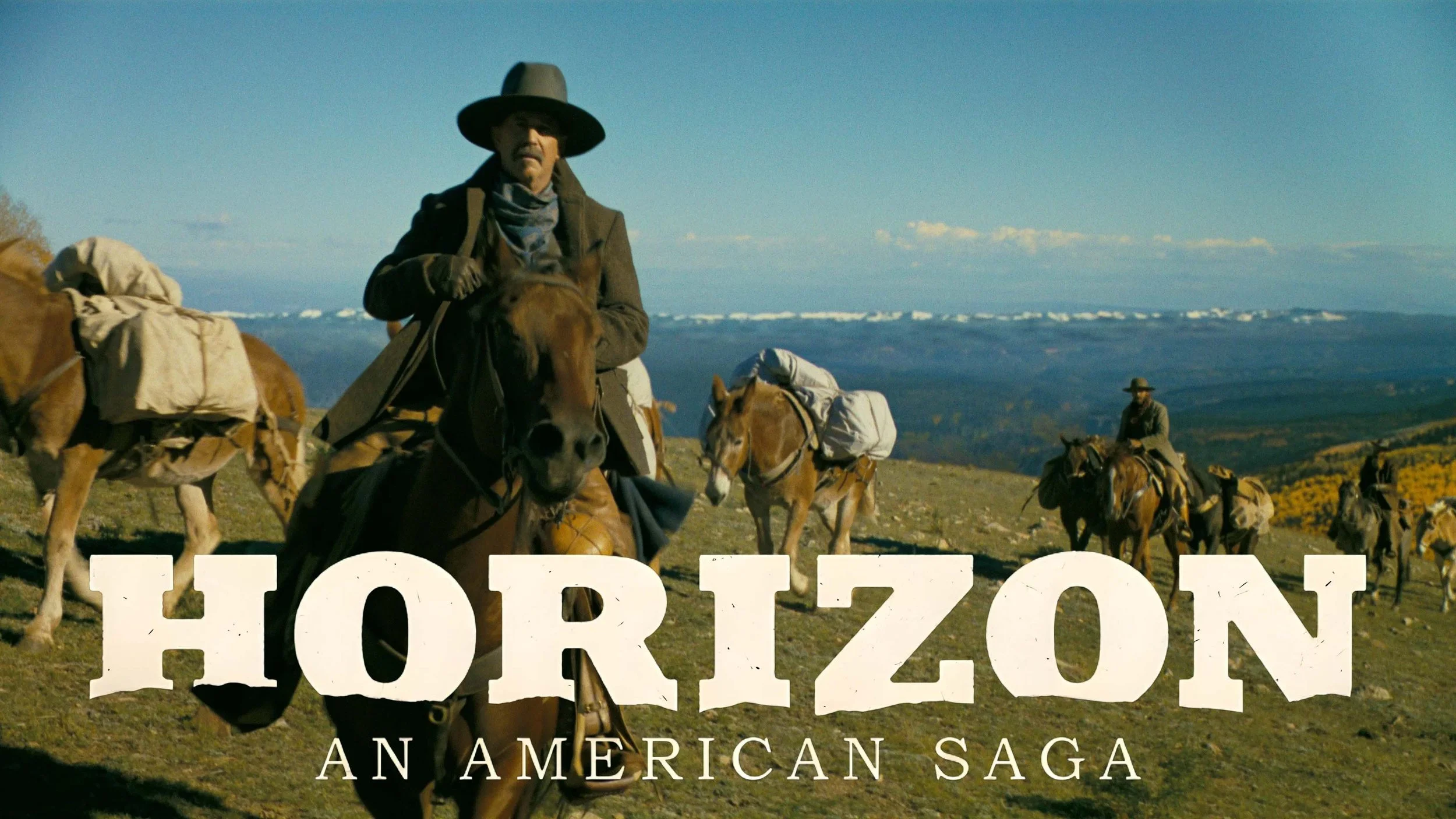A group of cowboys riding horses across a grassy landscape with mountains and a blue sky in the background. The scene is part of a Western film poster titled 'Horizon: An American Saga'.