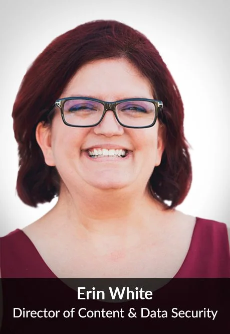 Close-up portrait of Erin White smiling, wearing glasses and a maroon top, against a blurred outdoor background.