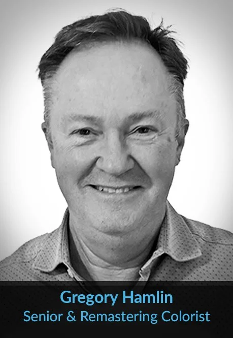 Black-and-white portrait of Gregory Hamlin, a senior and remastering colorist, smiling and wearing a collared shirt.