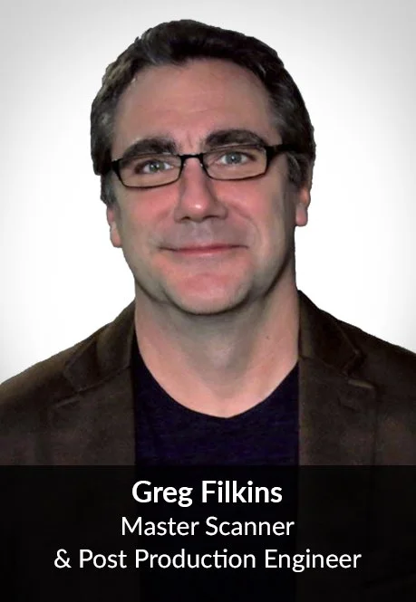 Professional headshot of Greg Filkins, Master Scanner & Post Production Engineer, wearing glasses and a dark blazer.