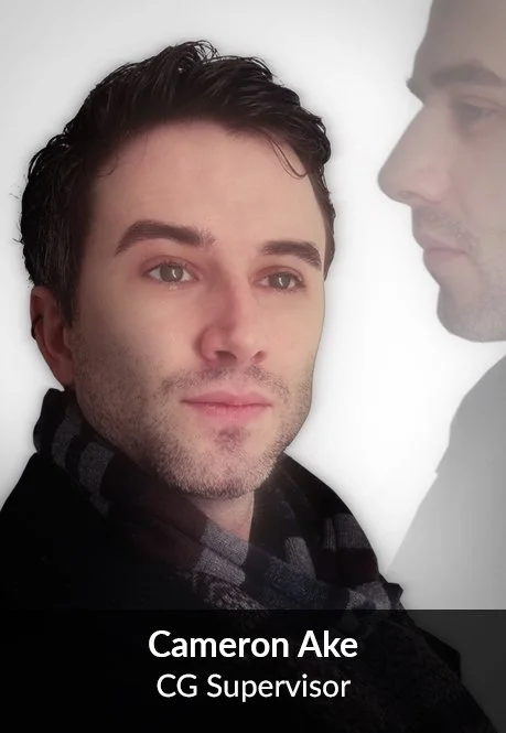 A man with dark hair and a beard-looking at his reflection or a transparent overlay of himself, with text overlay saying 'Cameron Ake, CG Supervisor'.
