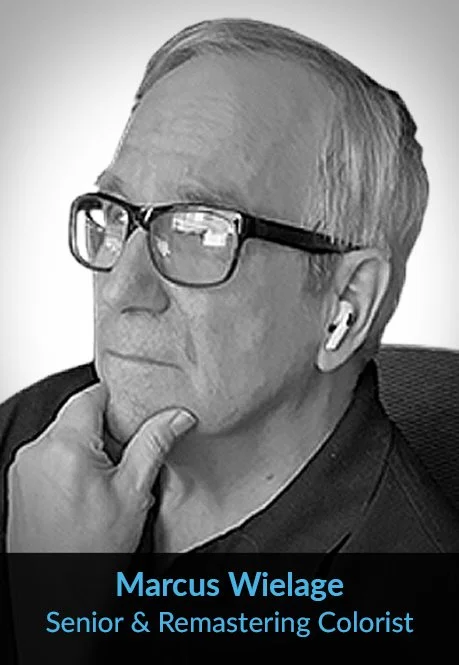 Black and white portrait of a man wearing glasses, with his hand on his chin, and listening to wireless earbuds, with text indicating name Marcus Wielage and profession as senior and remastering colorist.