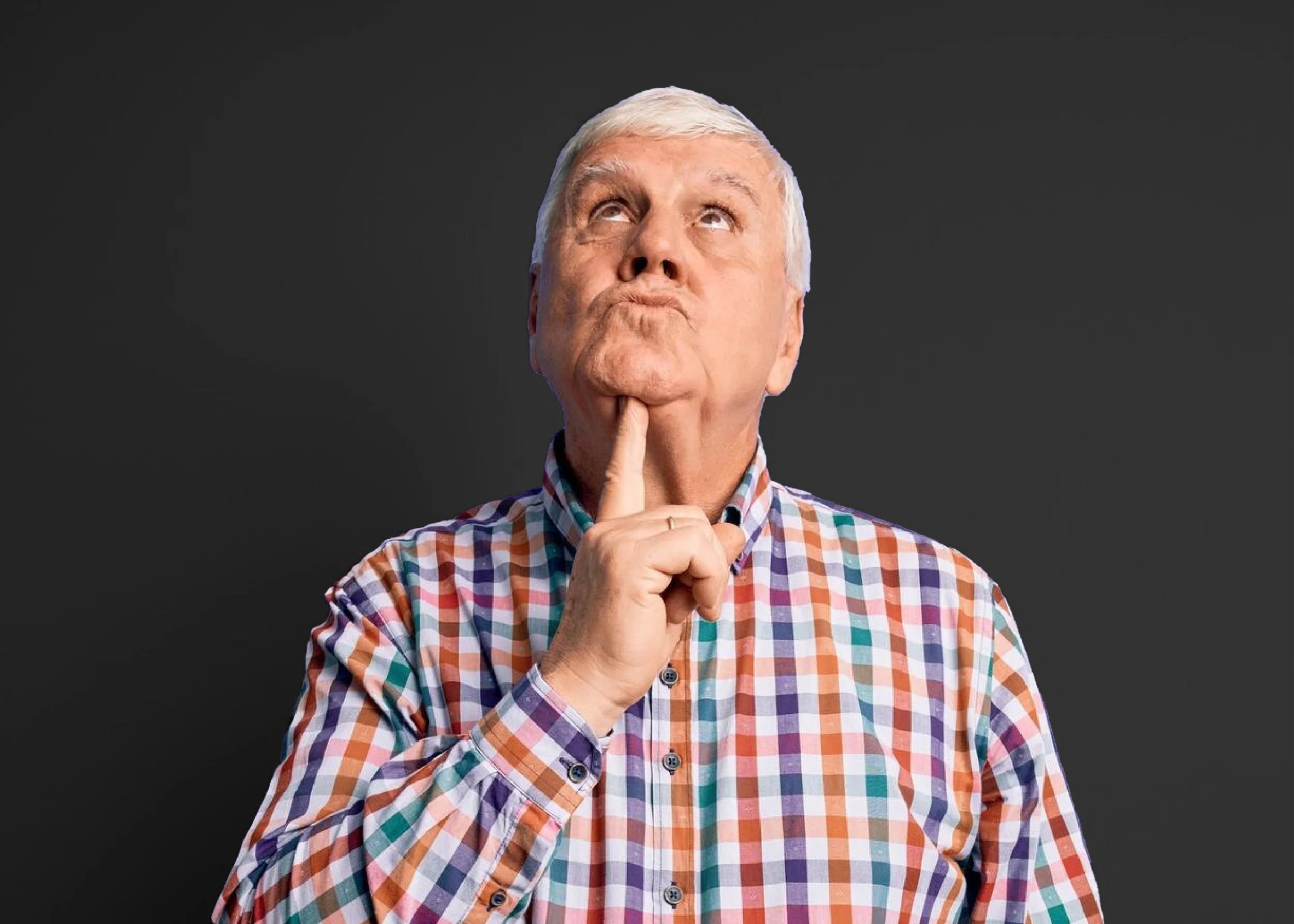 Older man with gray hair in a plaid shirt thinking with his index finger on his chin, against a dark background.