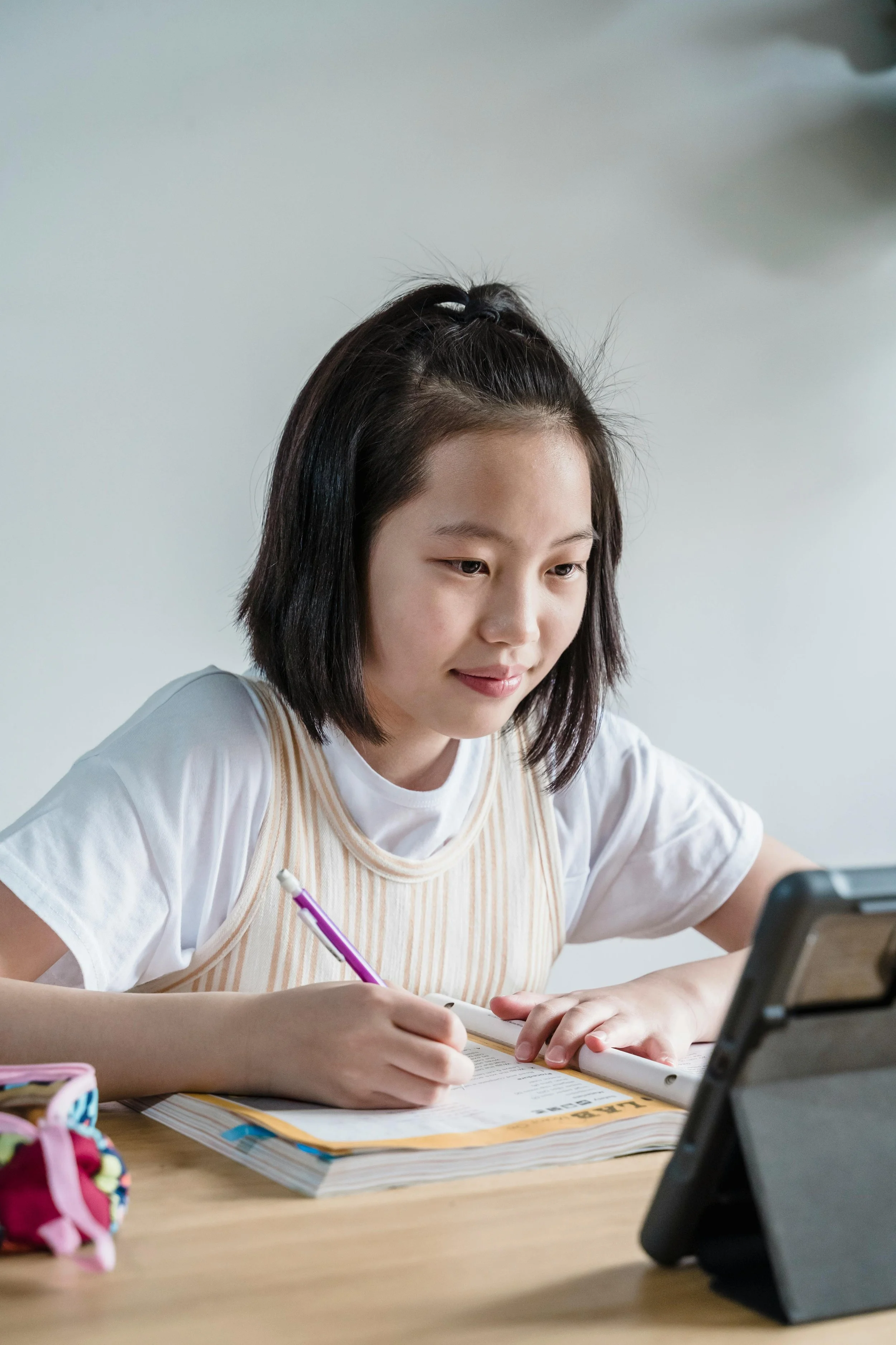 A student smiling at her tablet