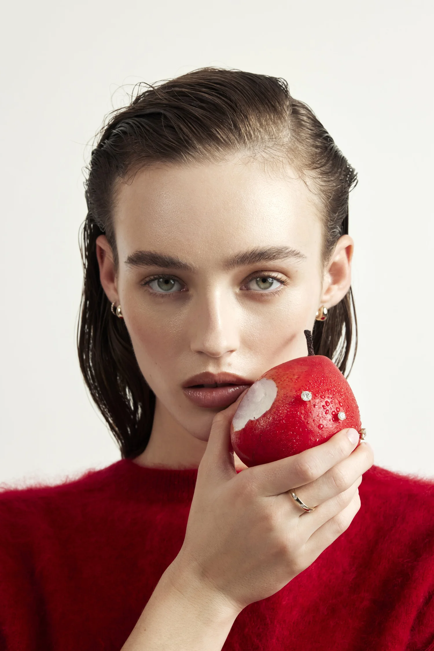 Model holding a red apple set with diamonds