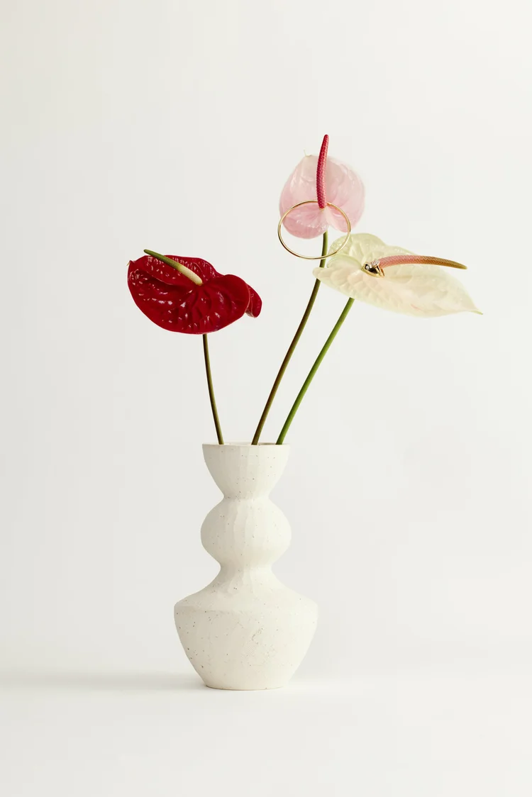 A diamond tennis bracelet on a red anthurium