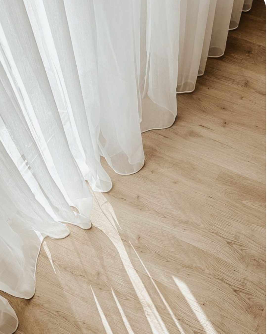 Interior design inspiration for 26 Pacific Ave in Greenville, SC, featuring light wood flooring and soft white curtains.