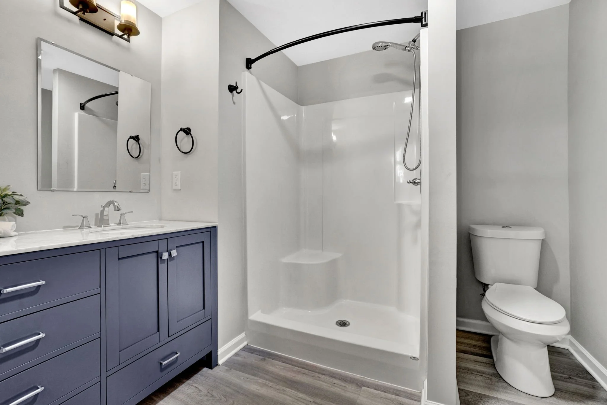 Renovated bathroom at 1317 Hub Wilson Road in Landrum, SC, featuring a blue double vanity, white countertops, a walk-in shower, and modern fixtures.