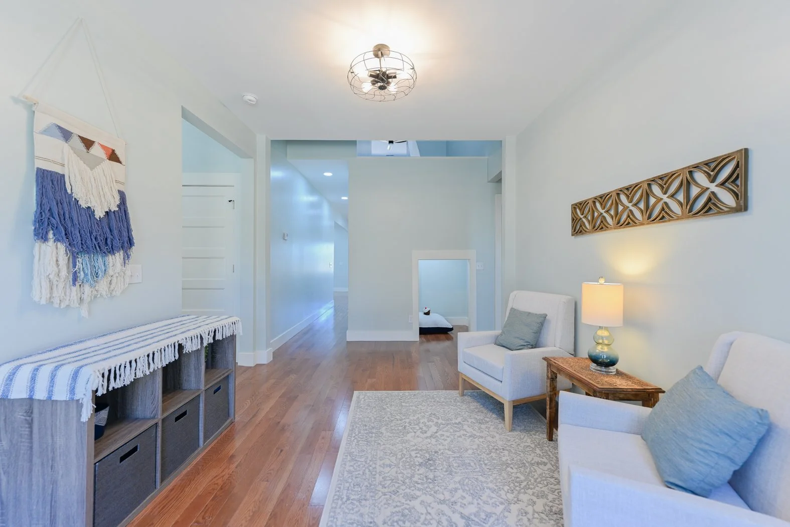 Renovated sitting area at 1334 Jameson Road in Easley, SC, featuring hardwood floors, soft neutral walls, contemporary lighting, and a cozy seating arrangement with built-in storage.