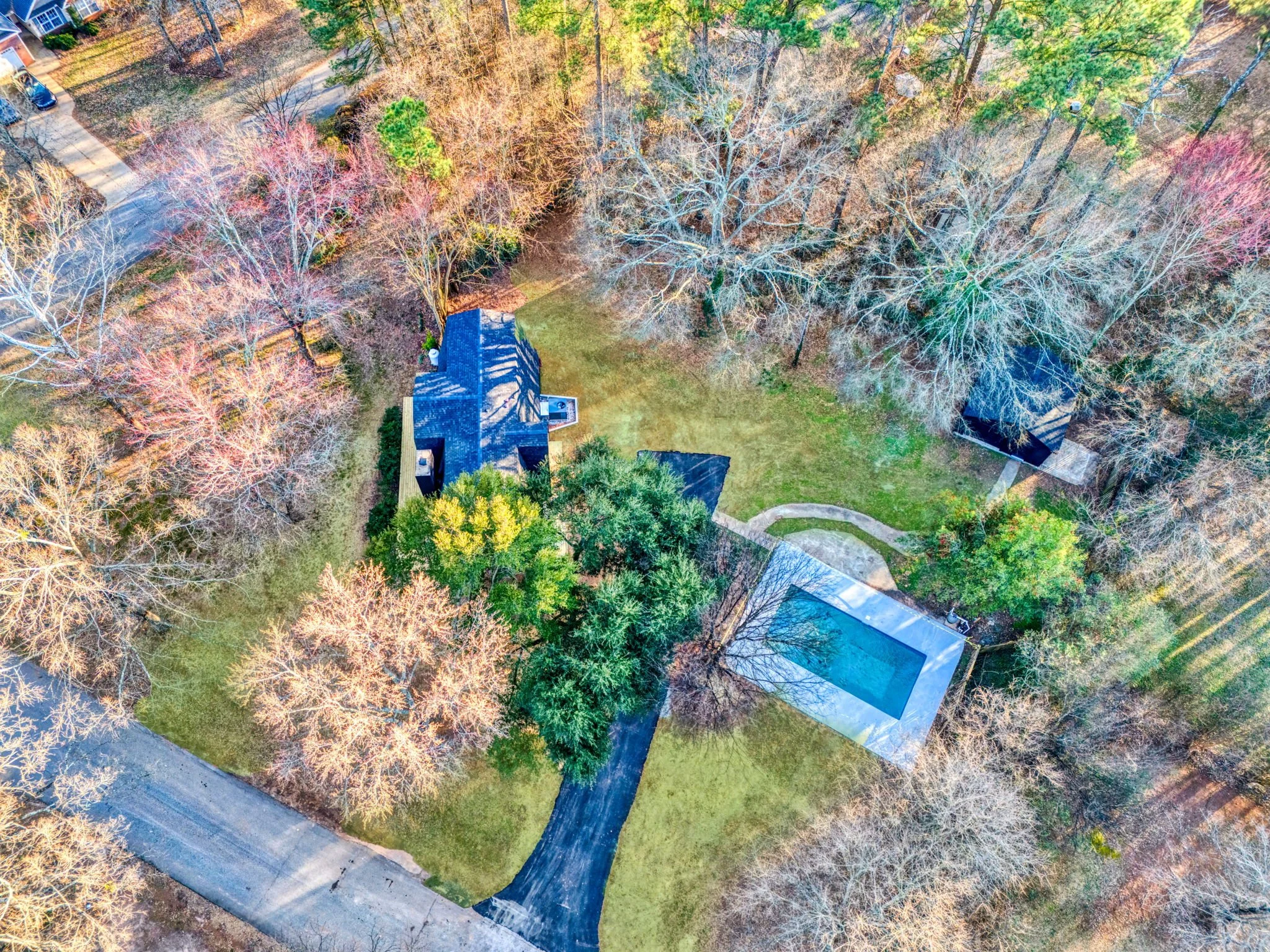 Aerial view of 112 Wayland Drive in Duncan, SC, showing the distinctive A-frame home, swimming pool, detached garage, driveway, and surrounding wooded property.