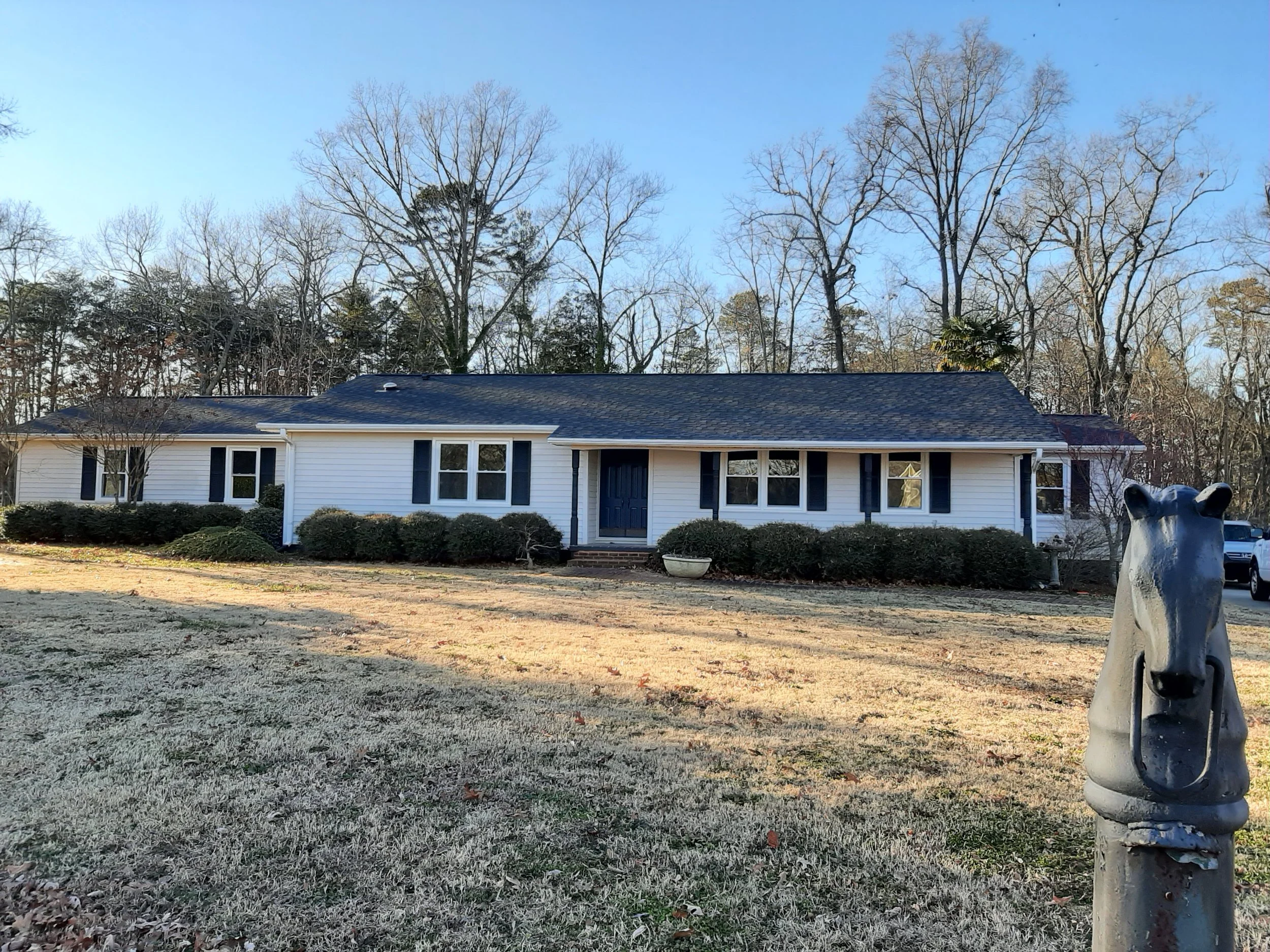 Renovated 1960s ranch-style home at 104 Medallion Lane in Lyman, SC, featuring white siding, dark shutters, a covered front porch, and a spacious landscaped lawn.