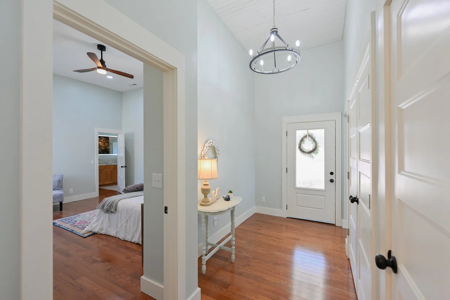 Renovated entryway at 1334 Jameson Road in Easley, SC, featuring hardwood floors, high ceilings, a glass-paneled exterior door, and access to the primary bedroom and bathroom.