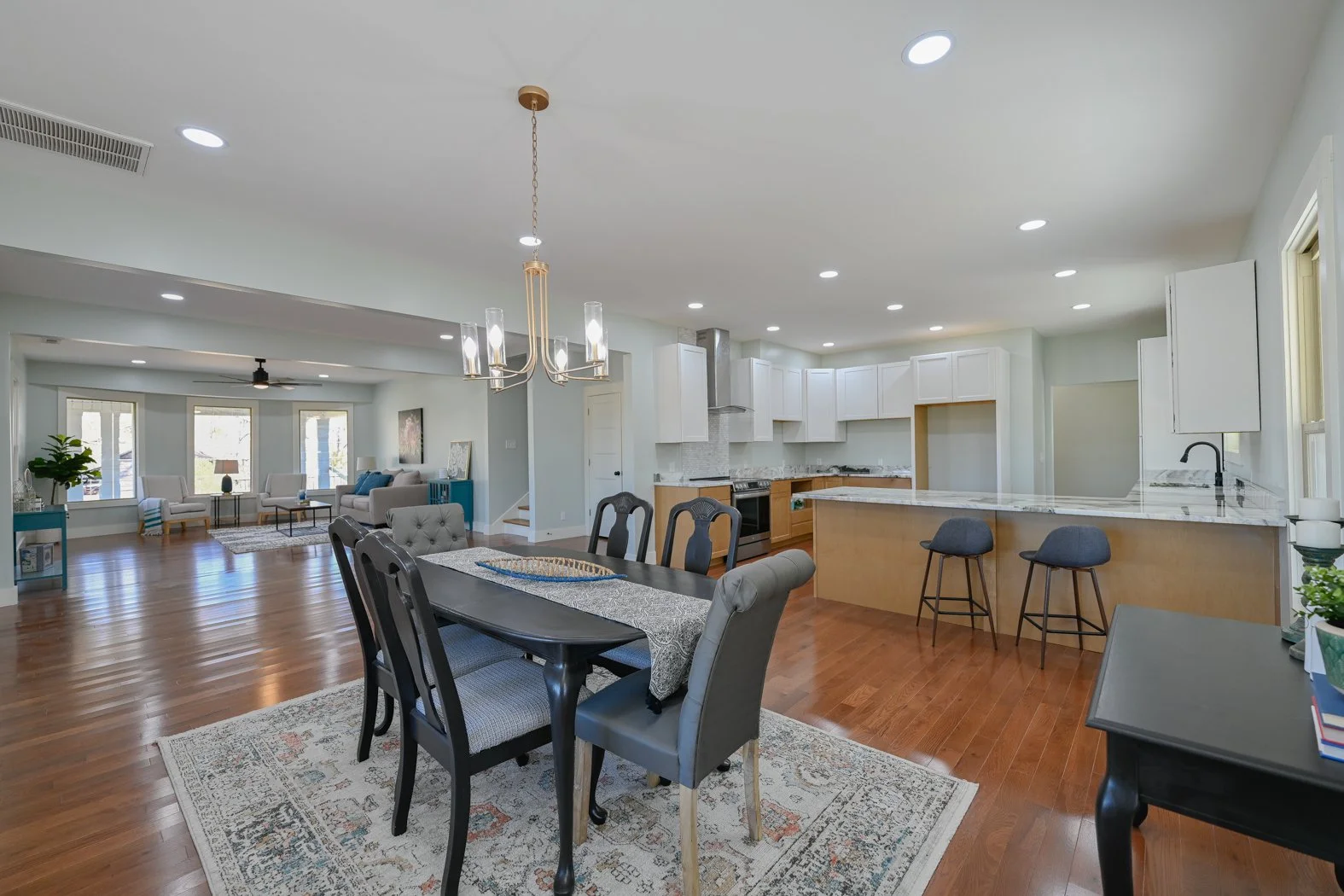 Renovated open-concept living and dining area at 1334 Jameson Road in Easley, SC, featuring hardwood floors, a spacious white kitchen with island seating, and a bright adjoining living room.