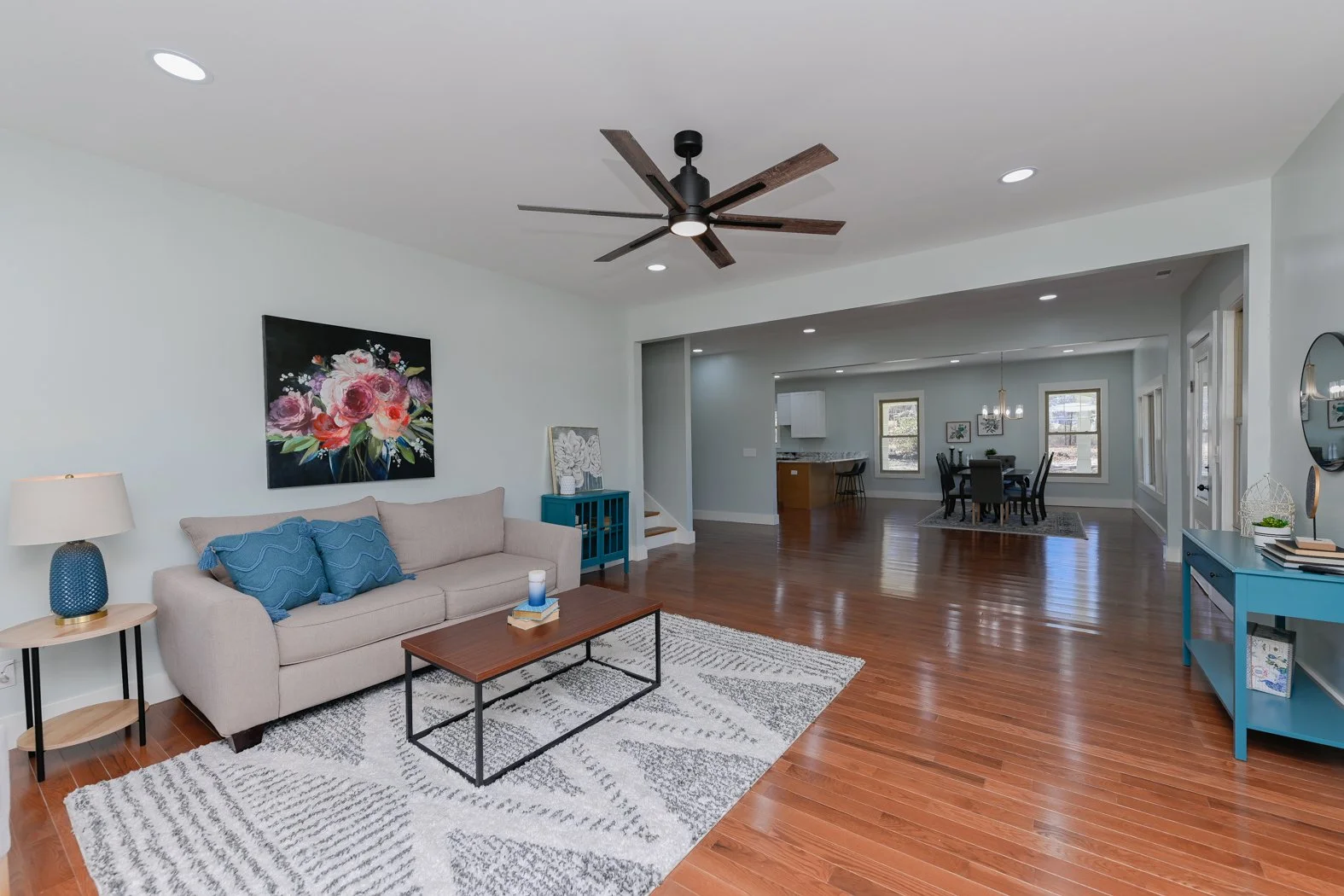 Renovated living room at 1334 Jameson Road in Easley, SC, featuring hardwood floors, recessed lighting, a ceiling fan, and an open layout connecting the living, dining, and kitchen areas.