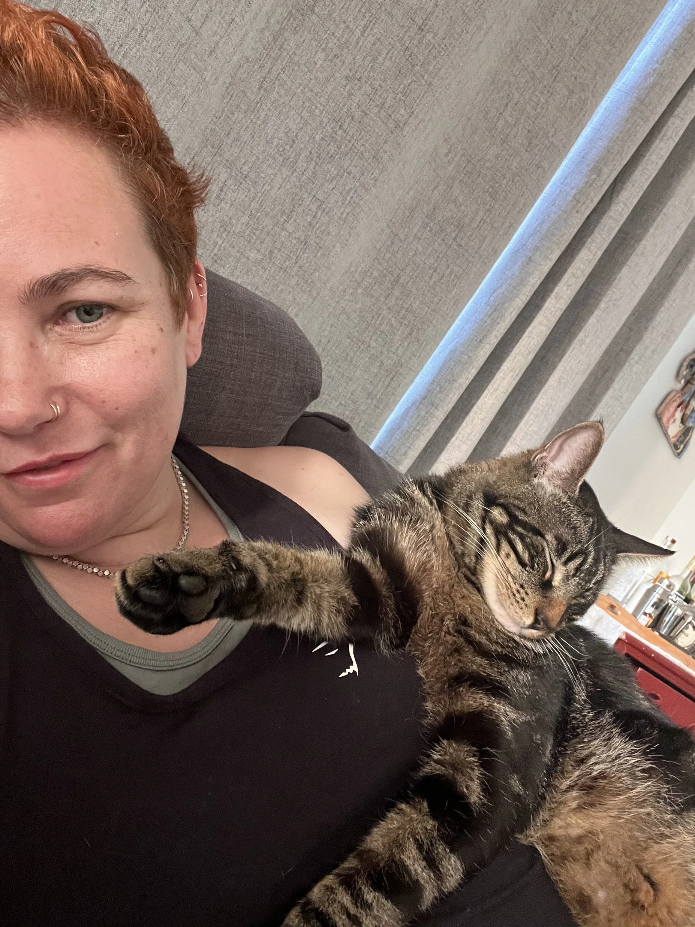 Alexa on a couch with their cat sleeping on their chest