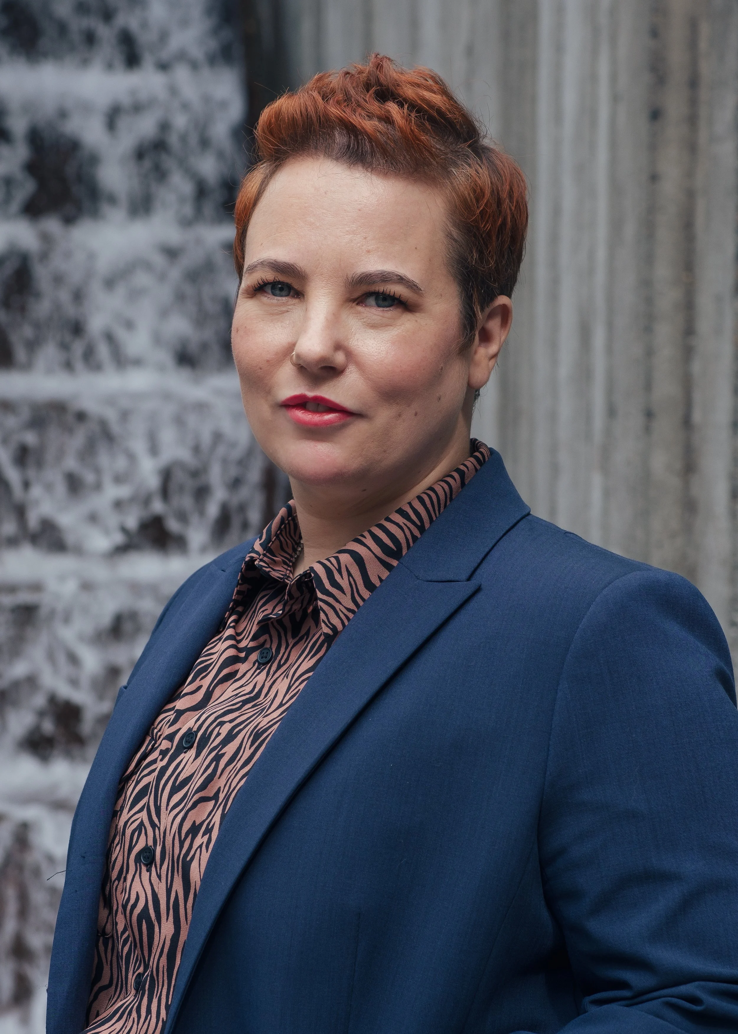 Alexa Lachman, standing in front of a brick background.