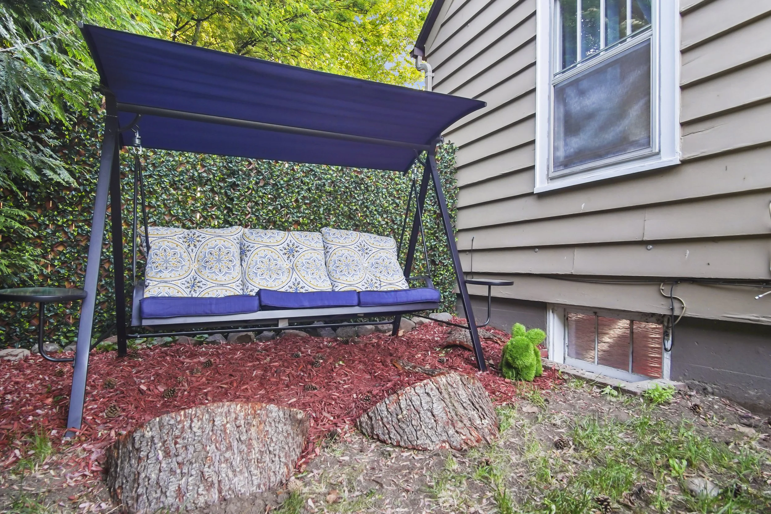 Covered Porch swing and yellow and blue cushions