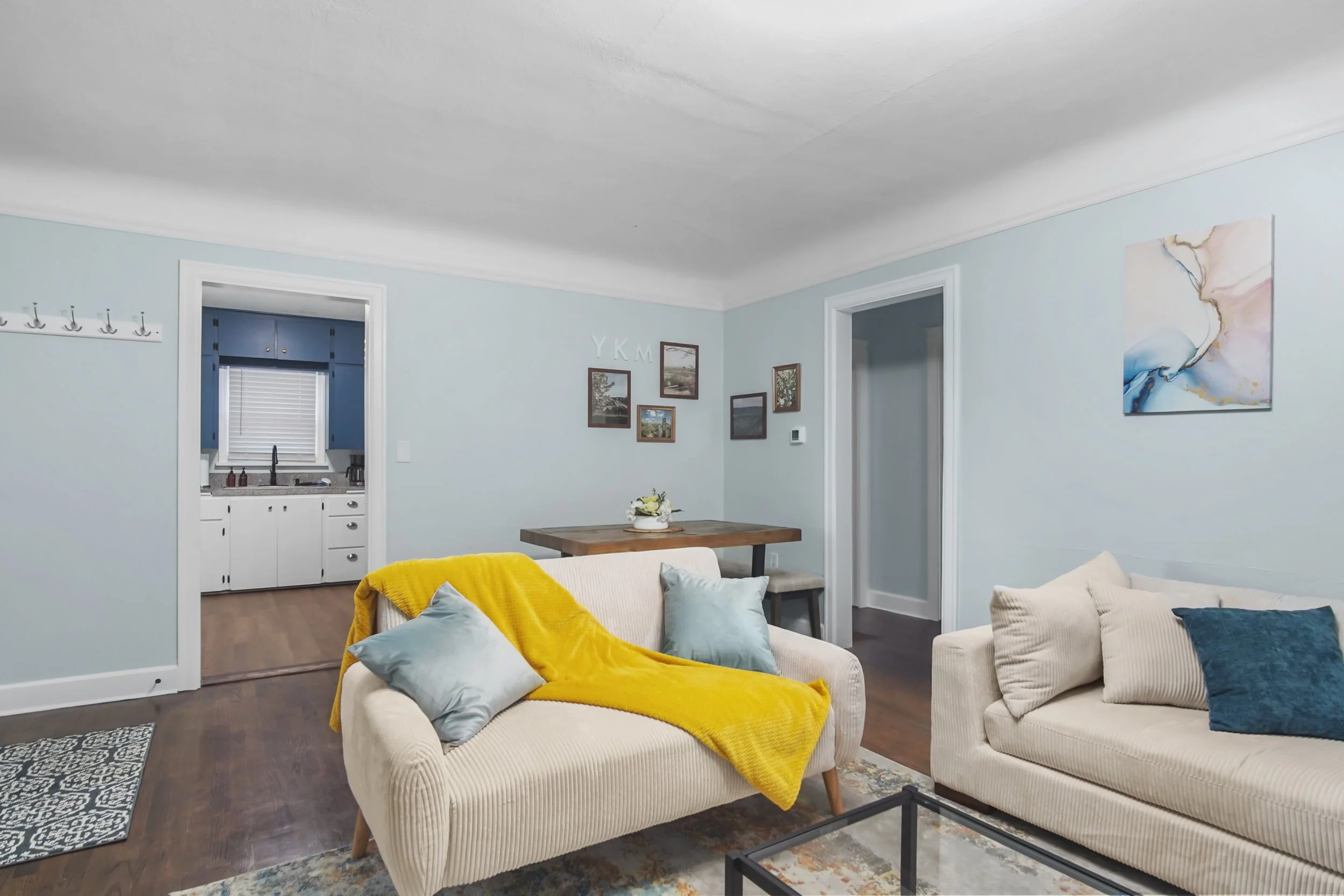 Looking through the living room into the kitchen and dining area with local photograghy