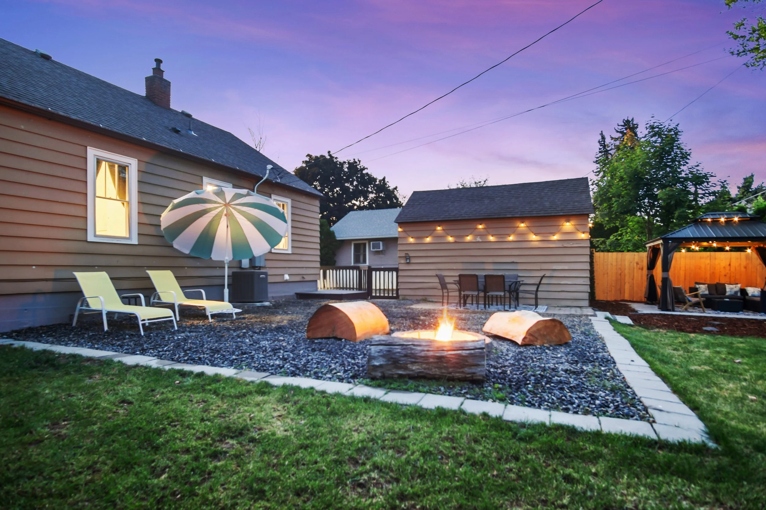 Glistening lights, a fire pit, sun seating and a dining area