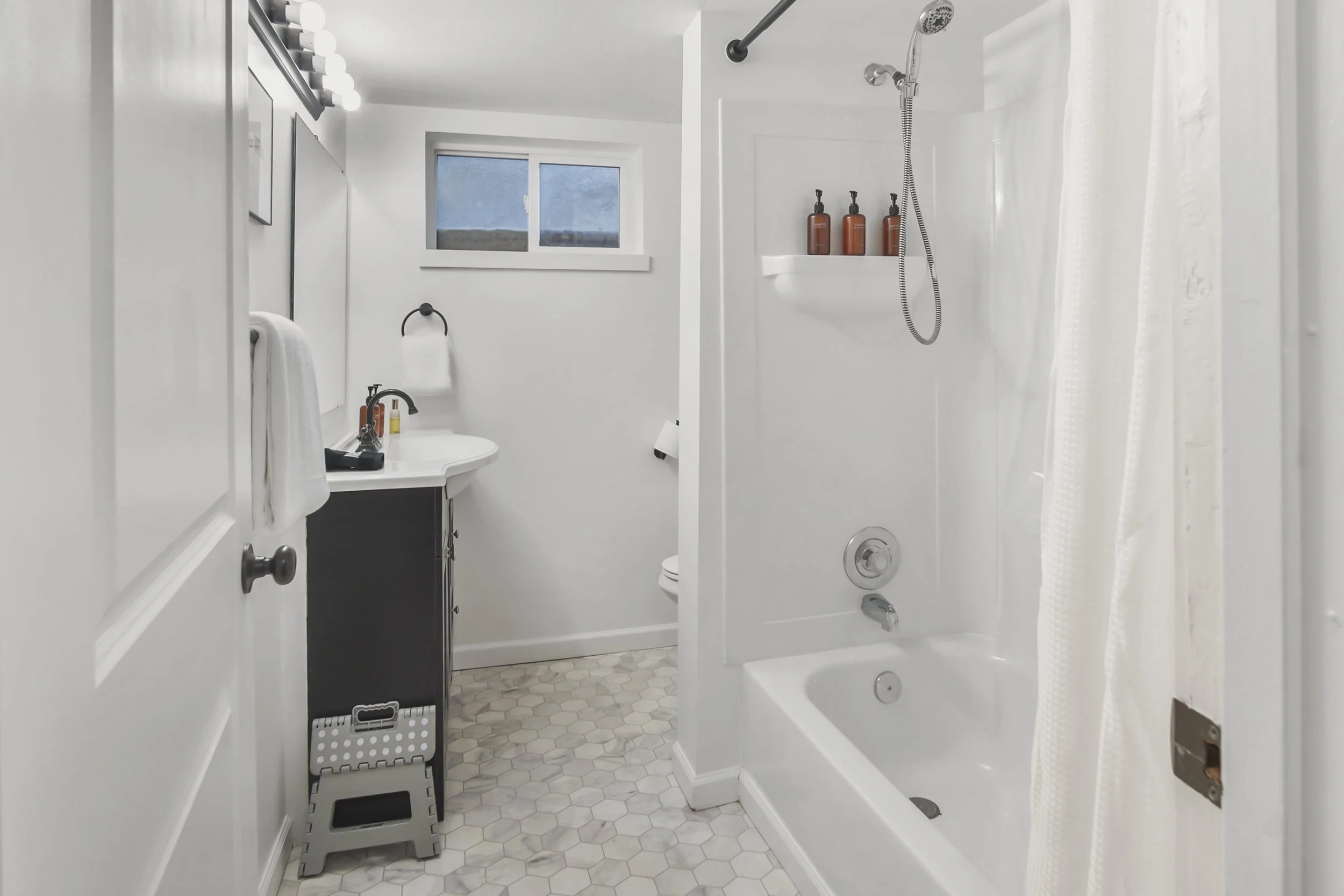Clean modern bathroom with soap, shampoo, conditioner, body wash, and lotion