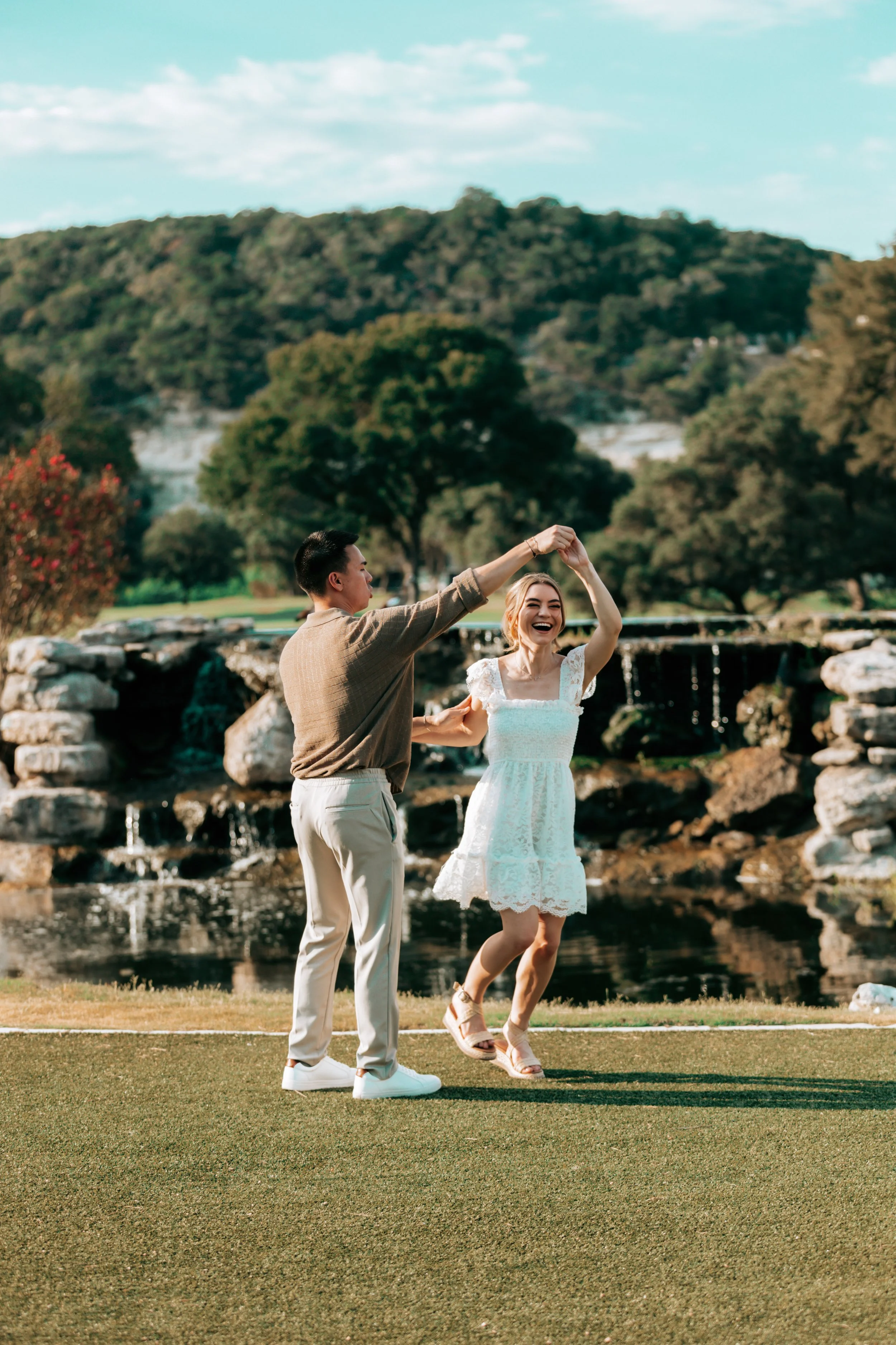 A couple dancing outdoors with a waterfall in the background