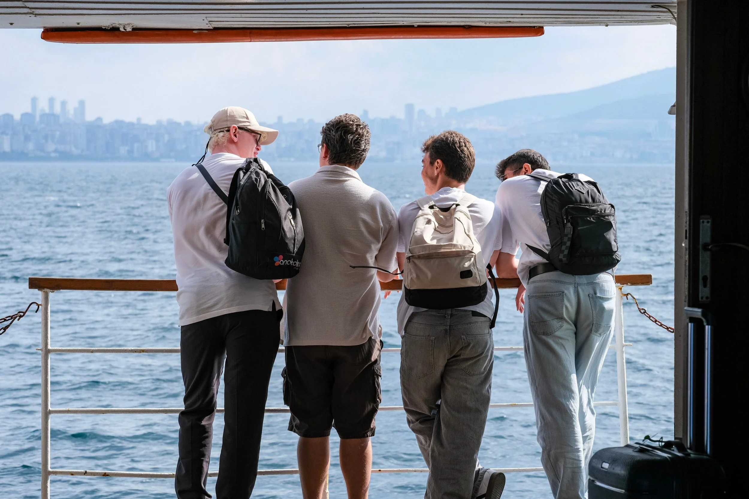 men with luggage overlooking water