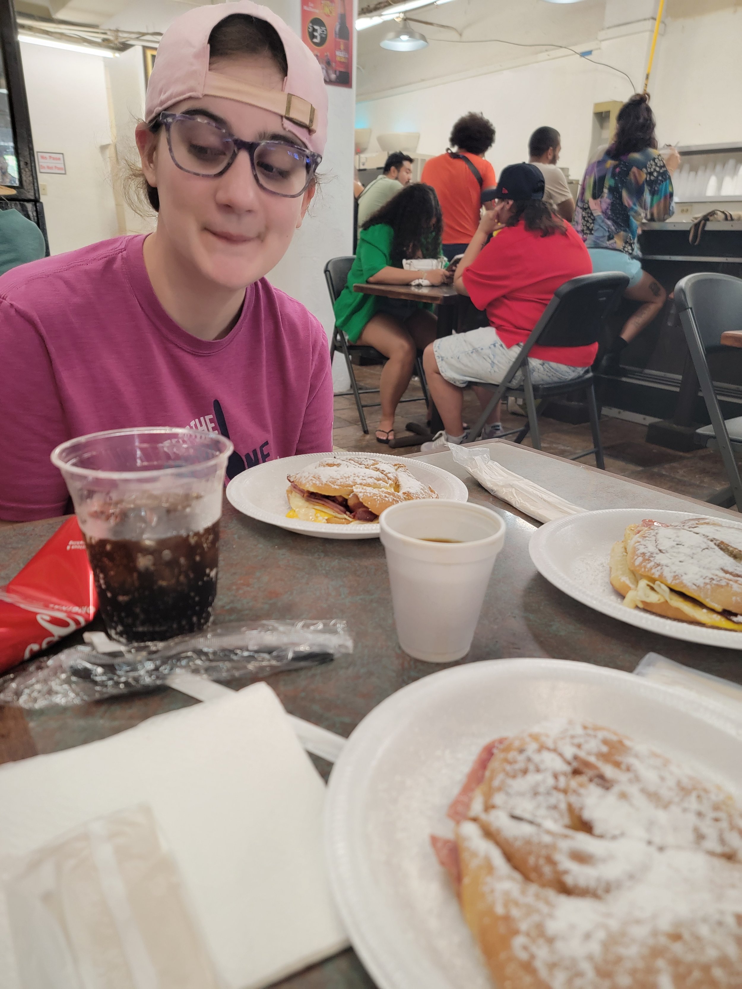 girl in ball cap looking at mallorca breakfast sandwiches in a casual restaurant