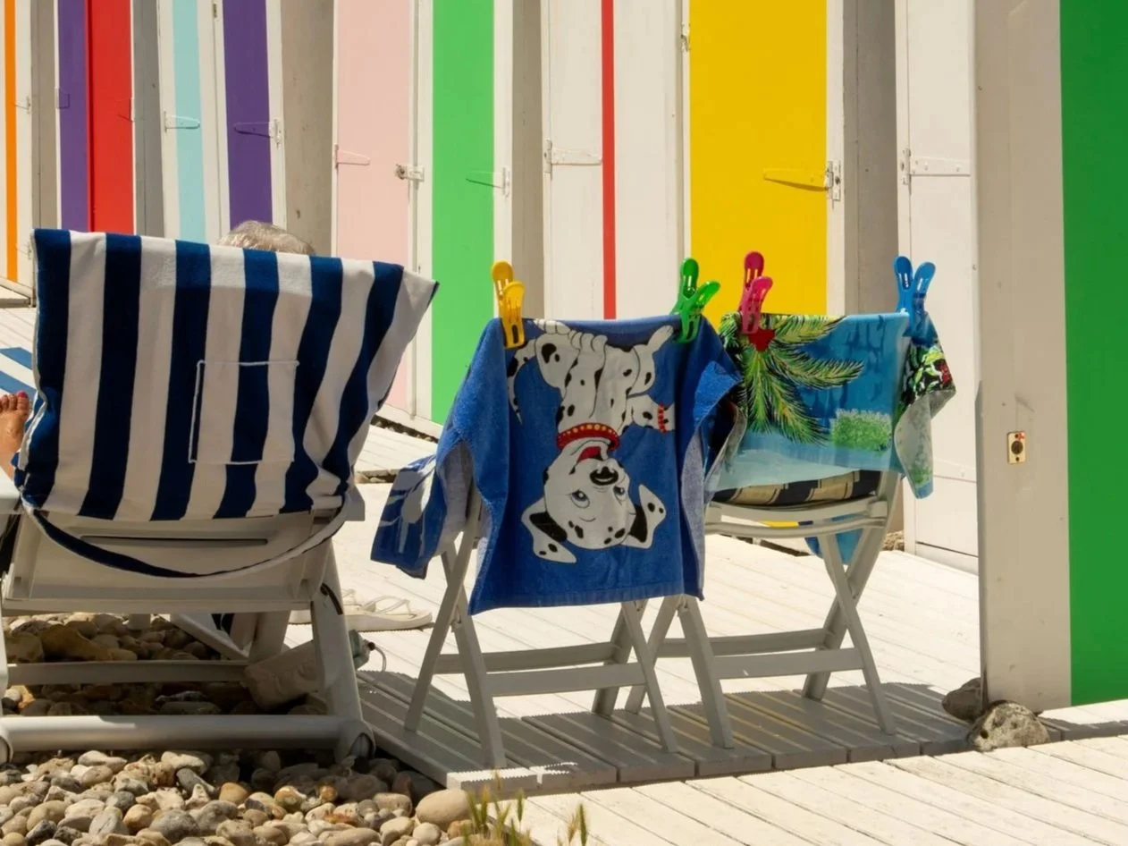 beach towels clipped to chairs in front of brightly colored doors