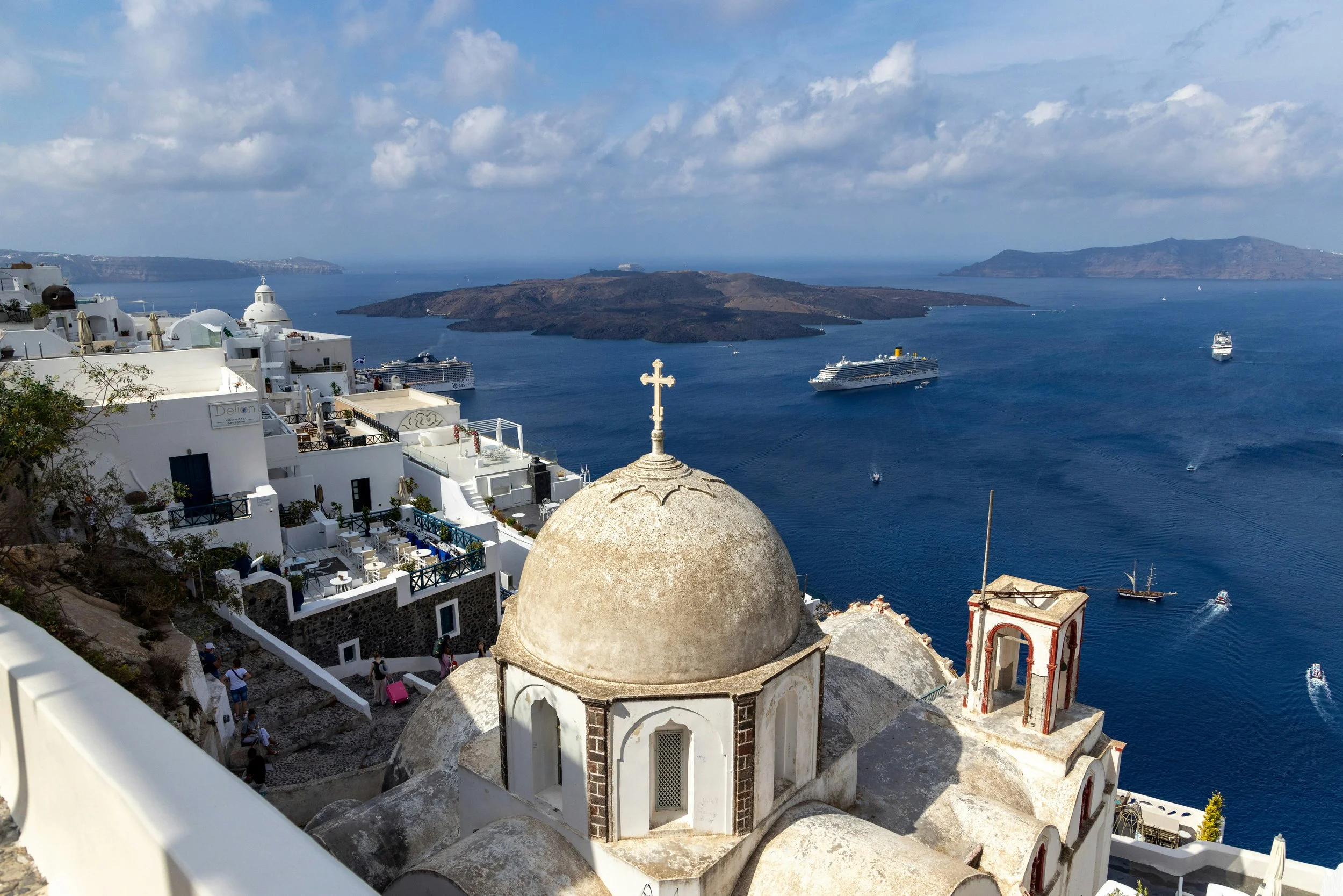 view of domed buildings in Greece overlooking cruise ship