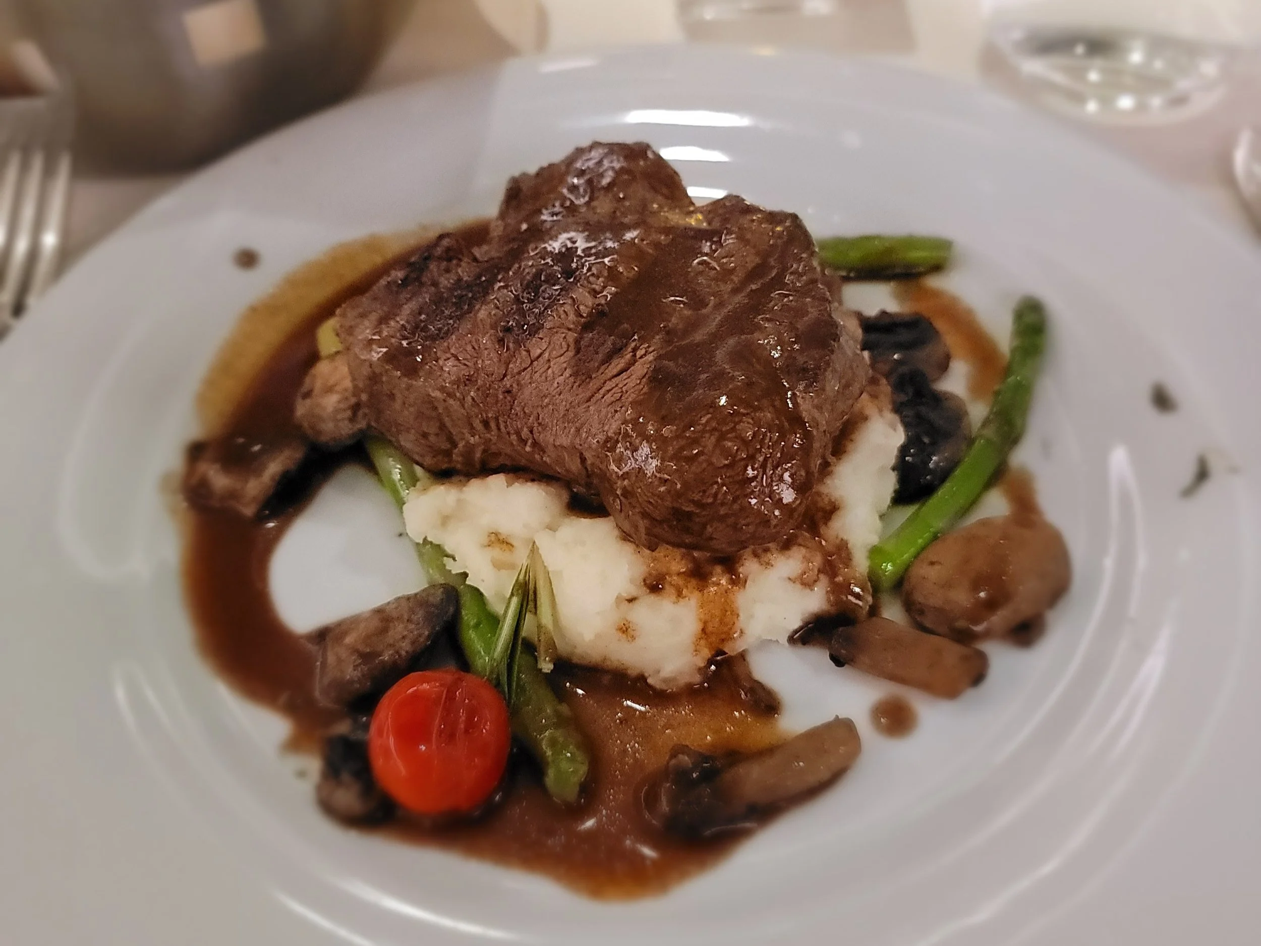 Steak over mashed potatoes and asparagus