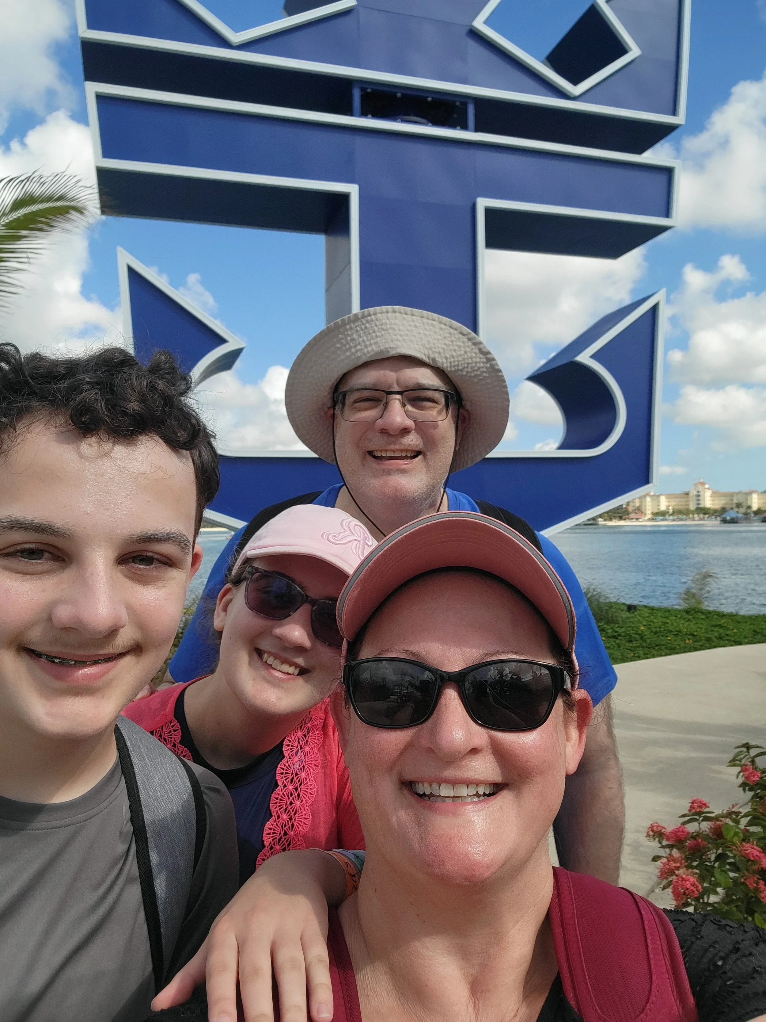 Family taking selfie in front of Royal Caribbean sculpture