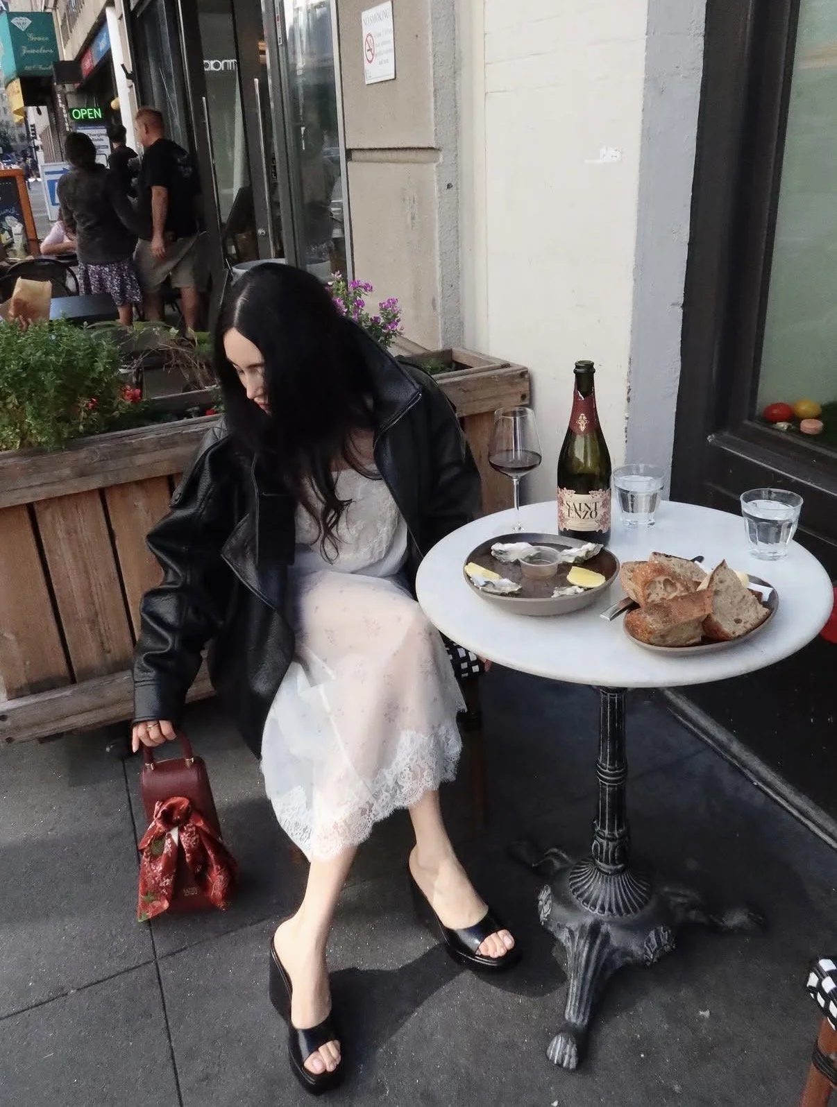 People clinking glasses of red wine during a festive meal with seafood, fruits, and snacks on a decorated table.