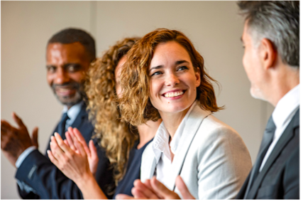 Candid photo of four people in professional attire applauding.