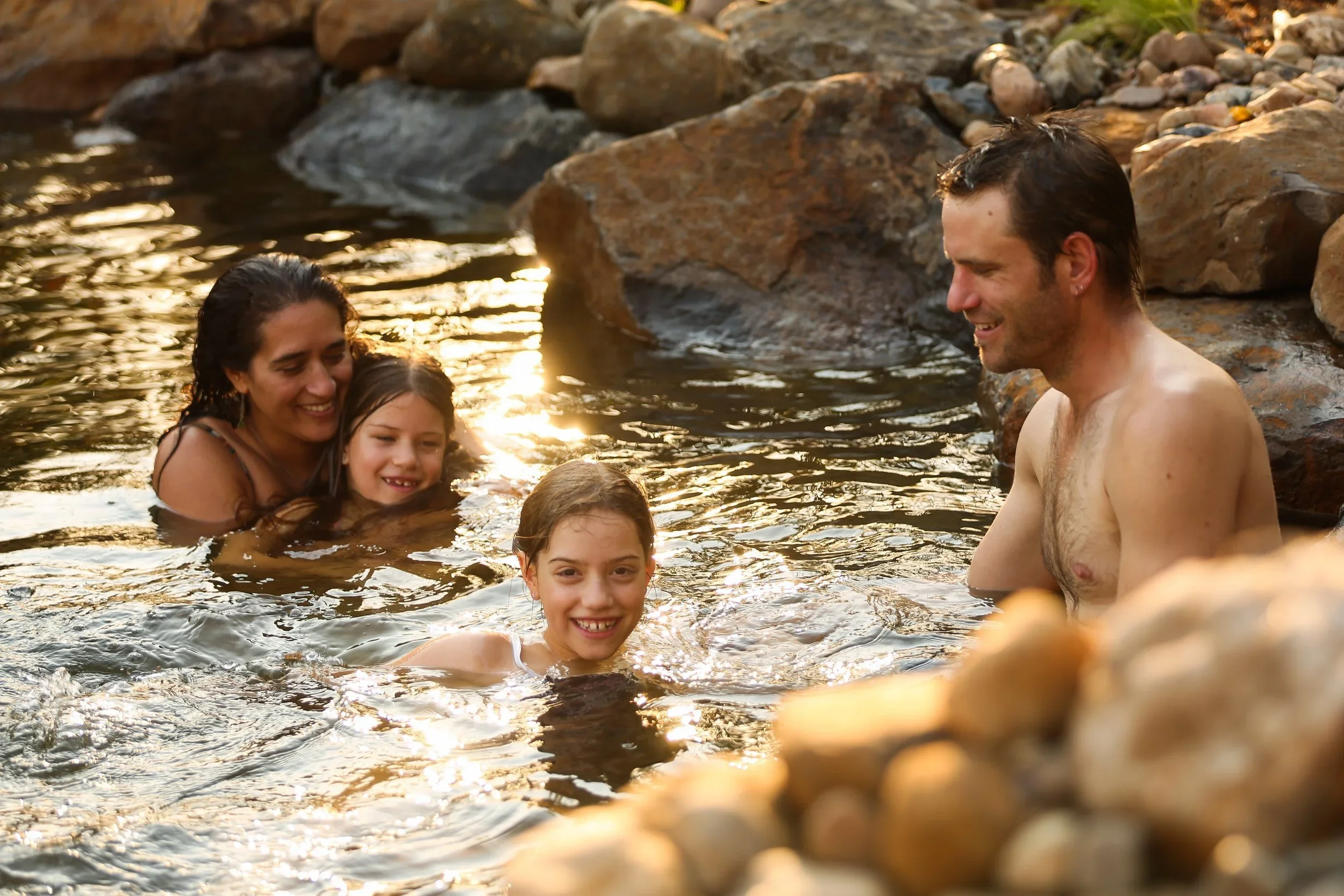 Family+in+a+natural+pool.webp