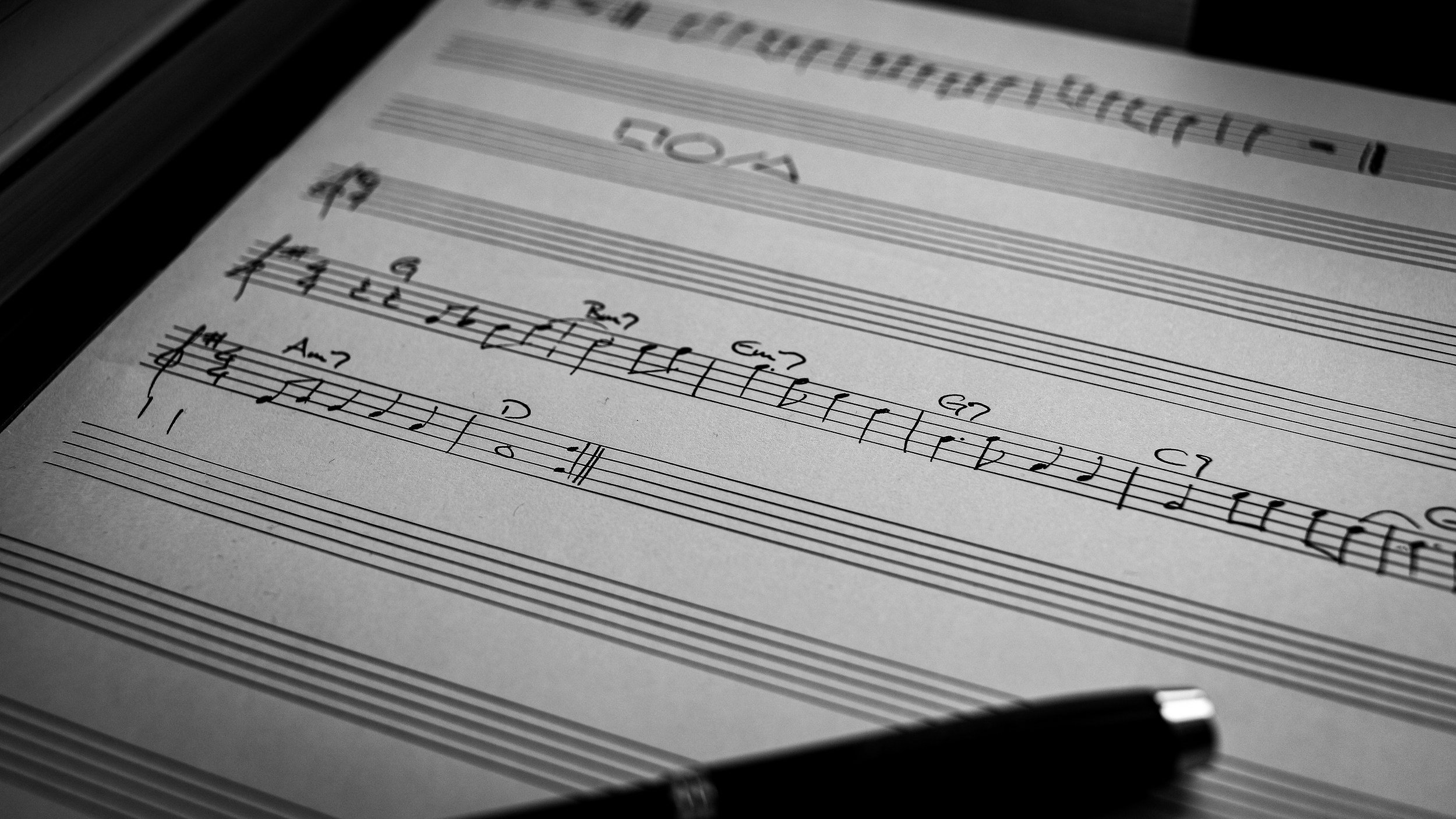 Sheet music with musical notation and handwritten notes on a music stand, black and white photograph.