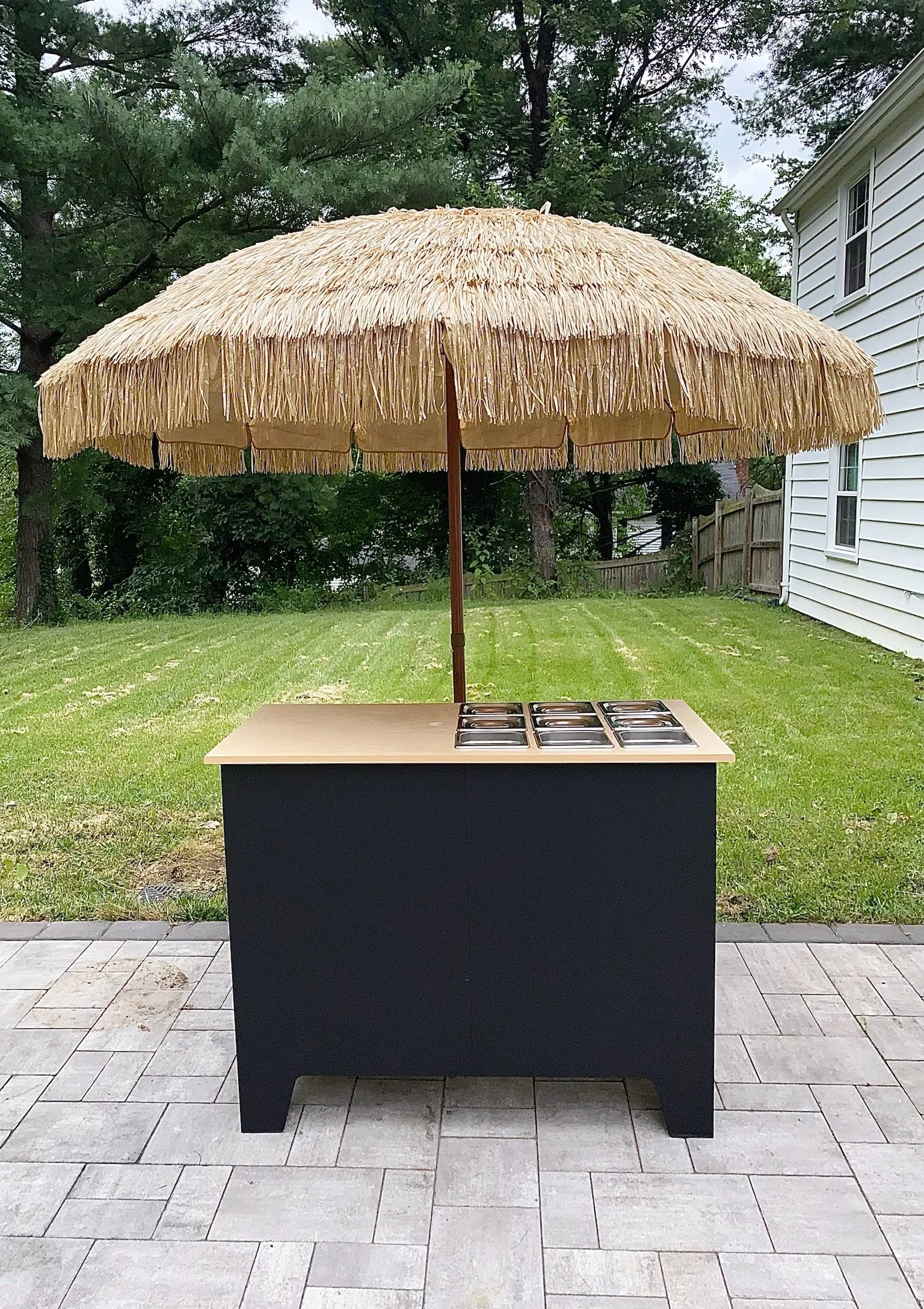 A snack cart with a large umbrella, ready for a party