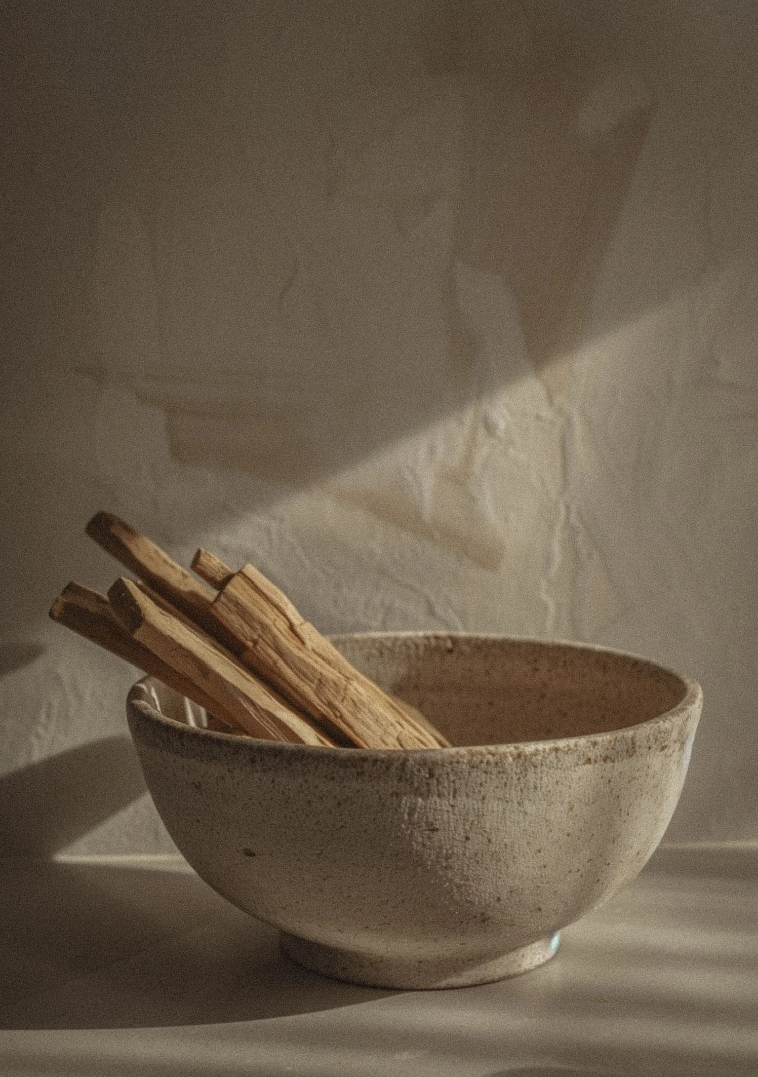 A young woman holding a glass cup with green tea, wearing bracelets, rings, and nail polish, with henna designs on hand.